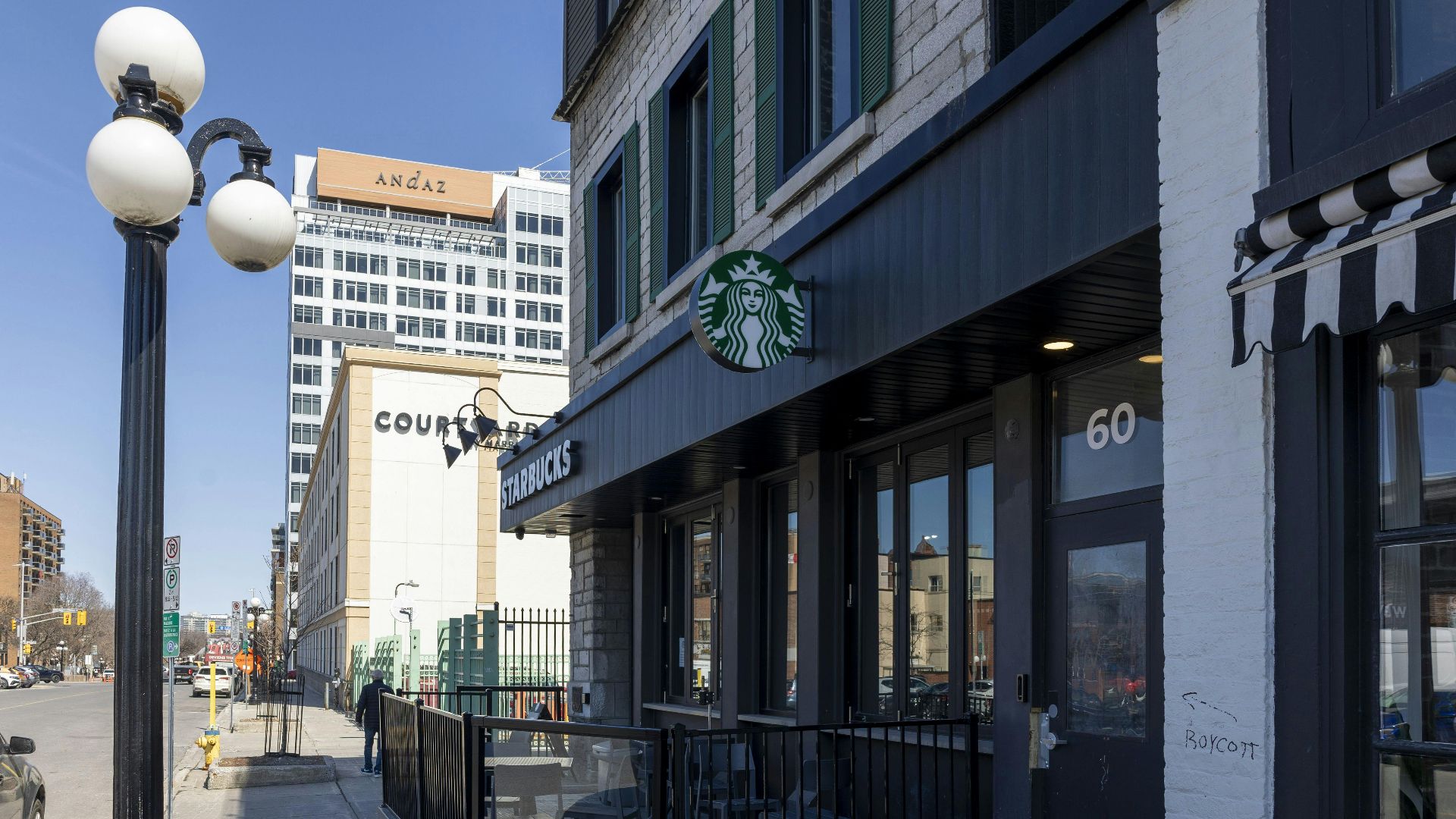 City street scene with Starbucks and modern architecture on a sunny day.