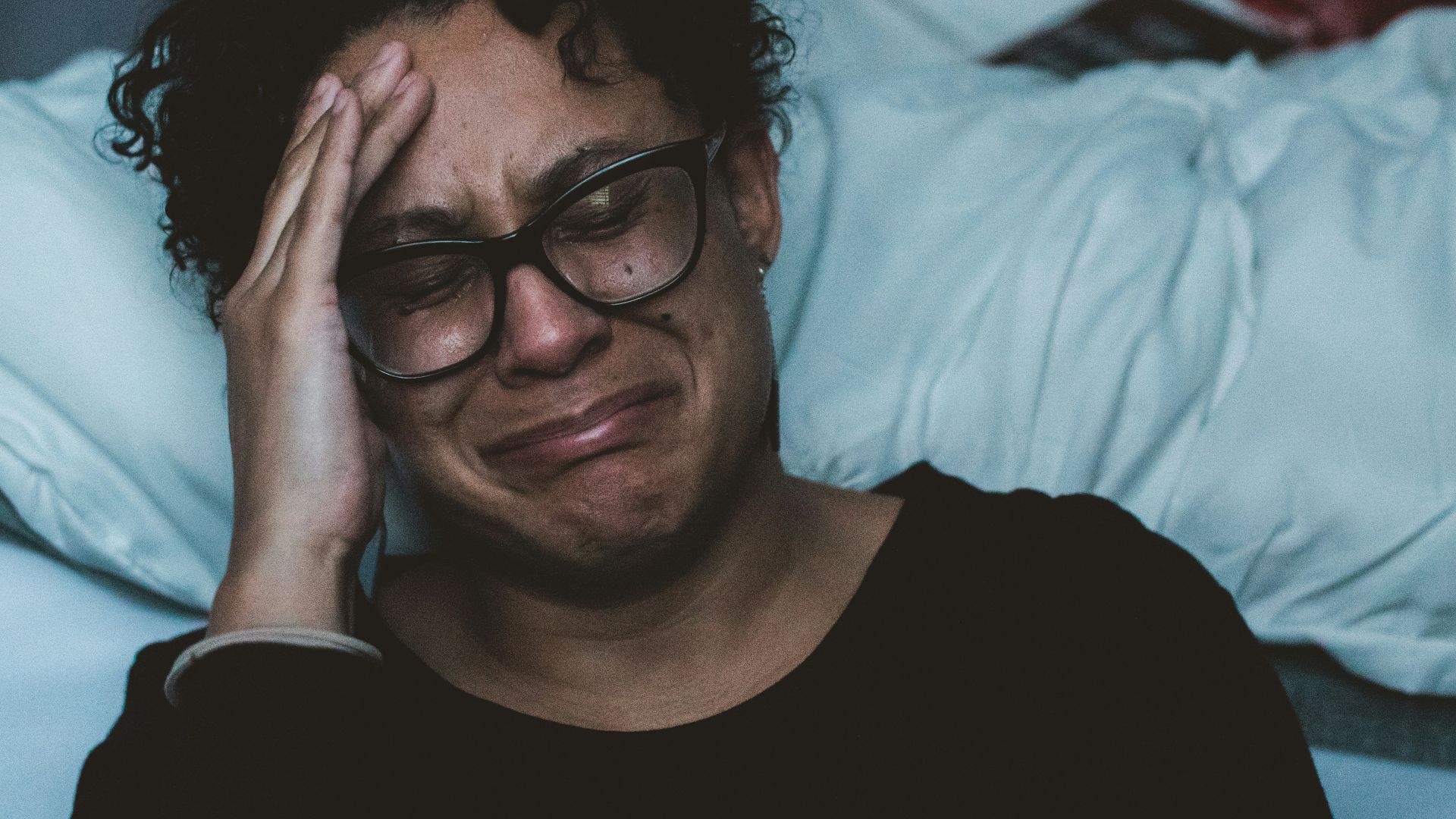 person crying beside bed