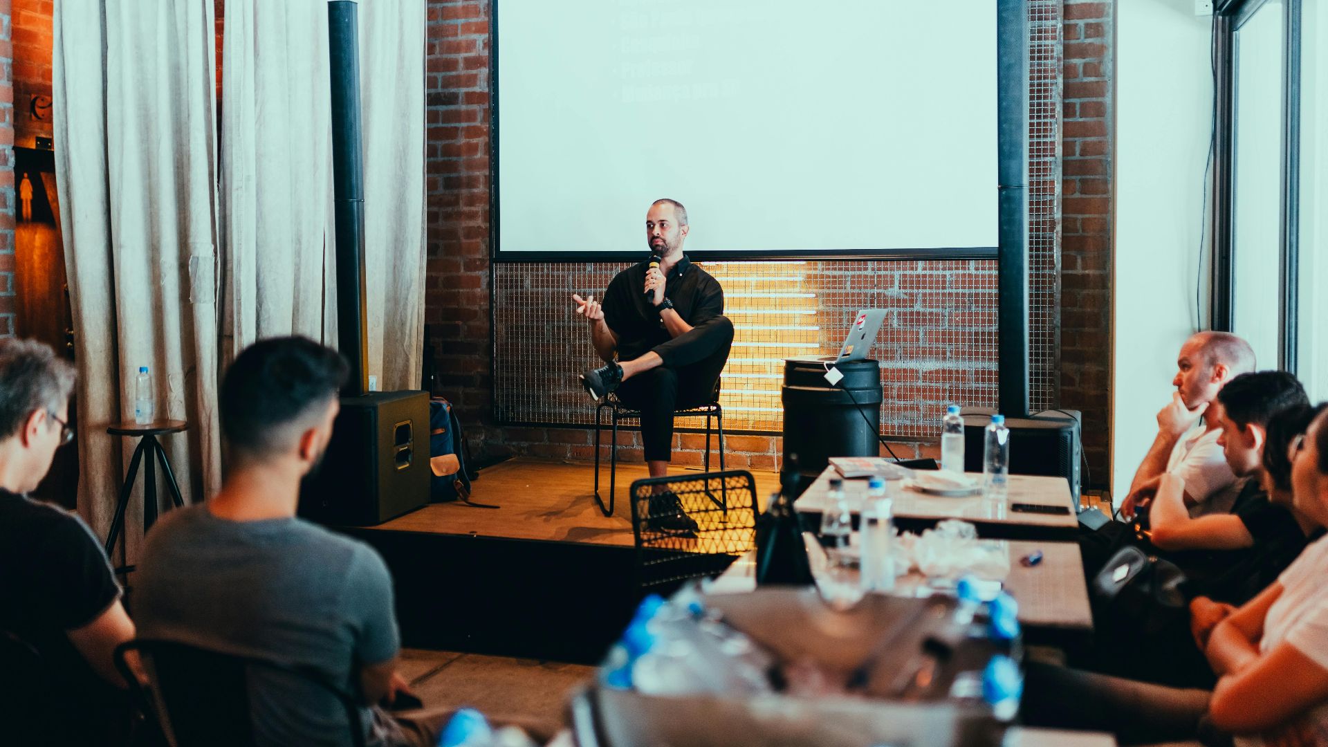 A business seminar with a speaker addressing an attentive audience in a modern conference setting.