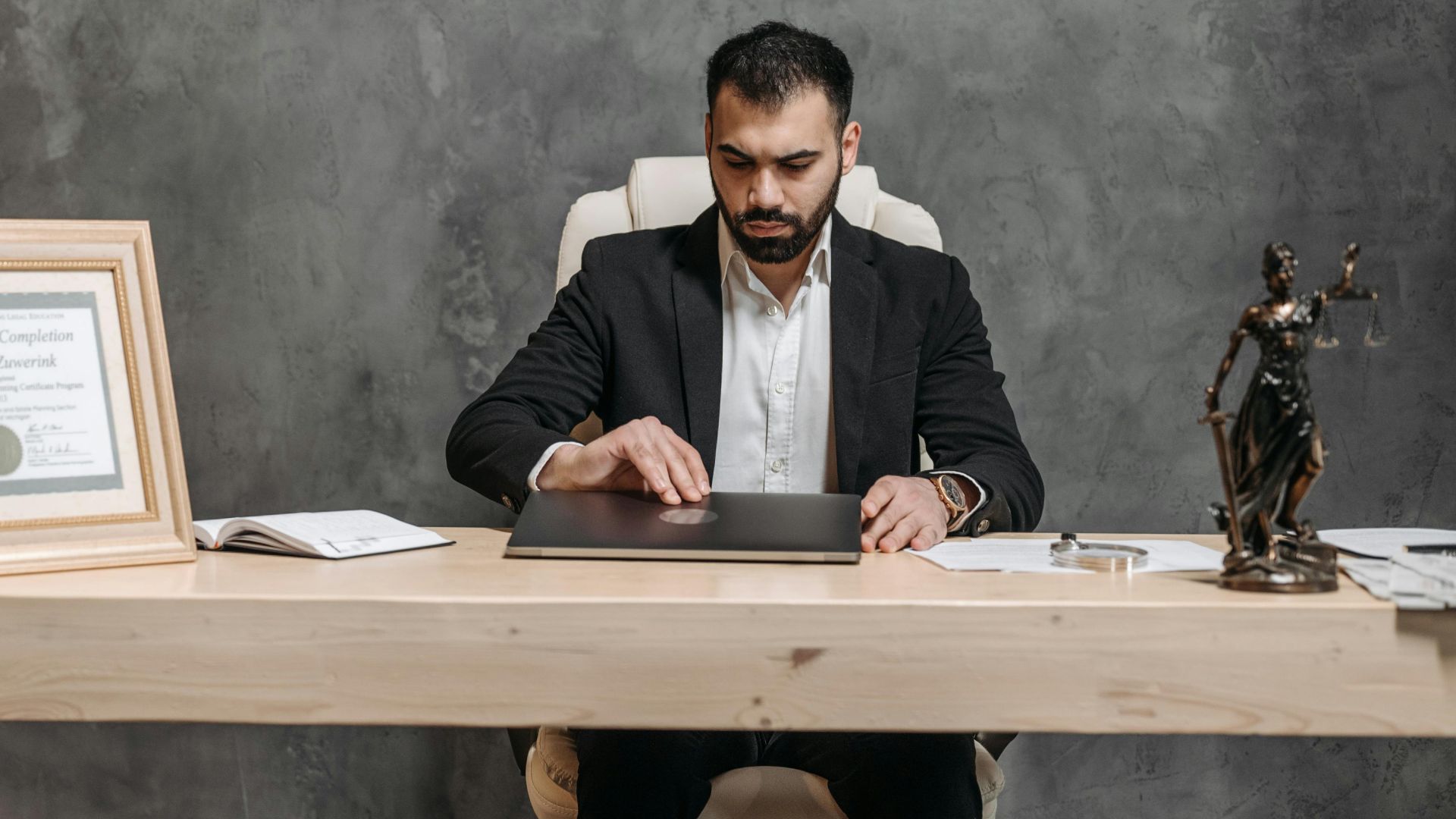 A bearded lawyer working at his office desk, showing professionalism and expertise.