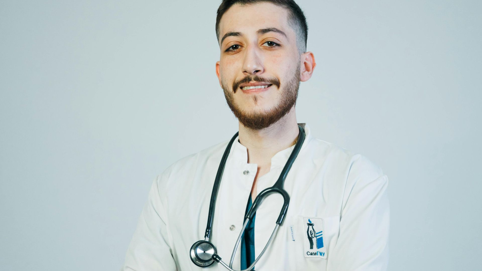 Portrait of a young male doctor with a stethoscope, exuding confidence and professionalism.