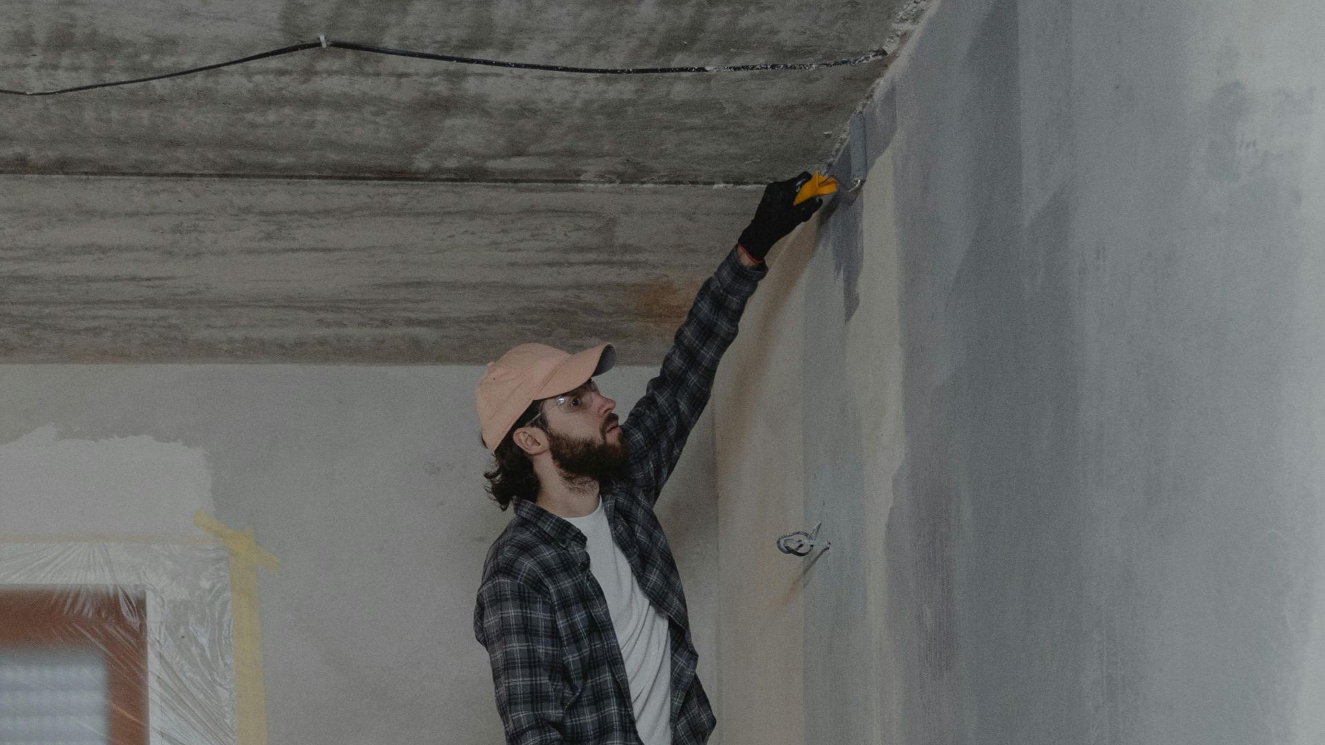 Young couple painting walls and doing home renovation together.