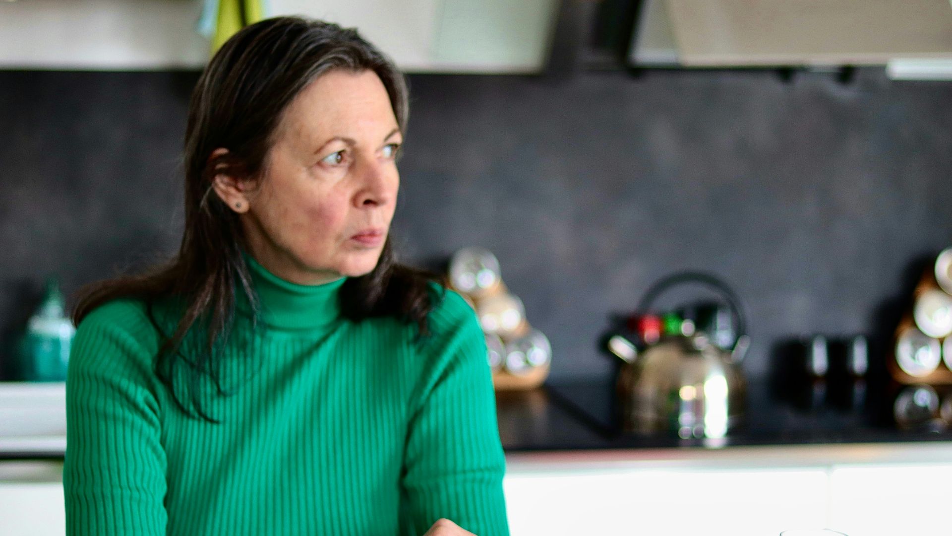 a woman sitting at a table in a kitchen
