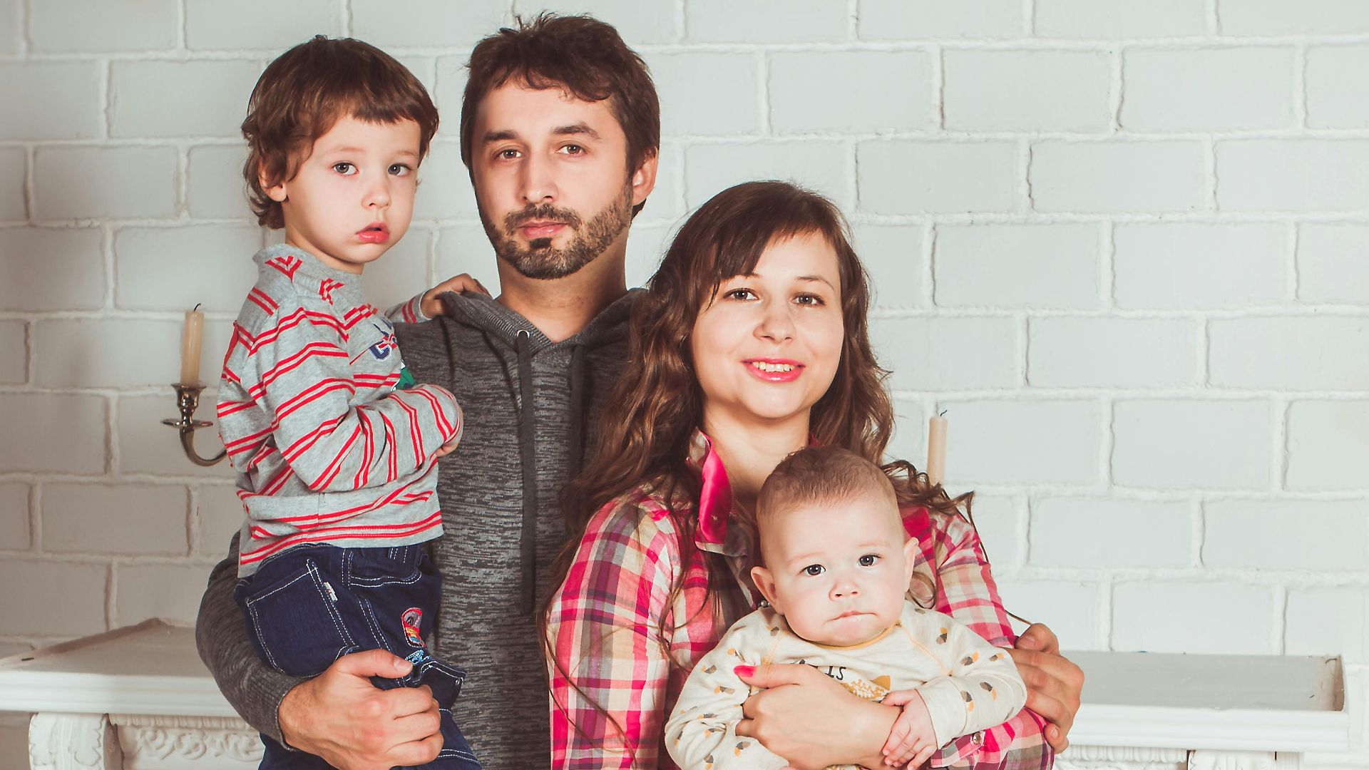 A joyful family posing together in a cozy living room, embodying love and togetherness.