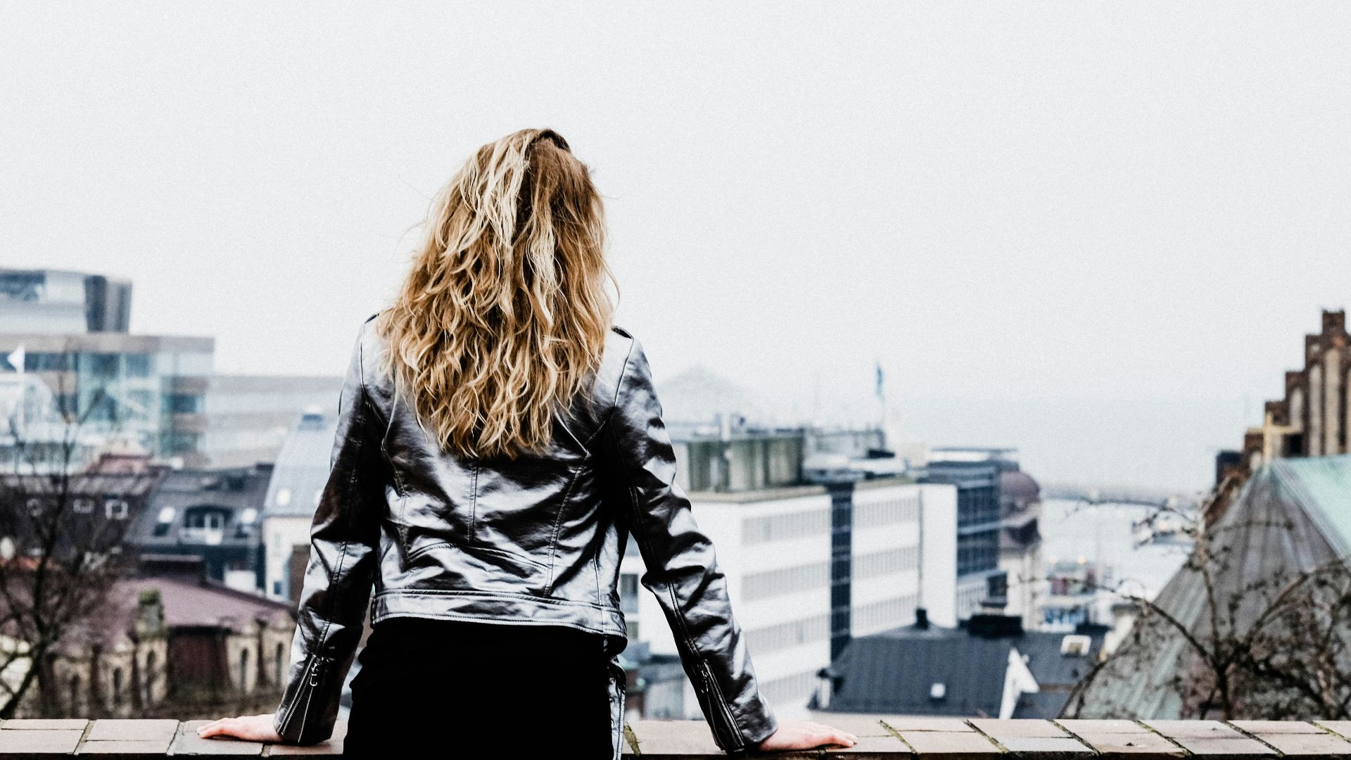 woman leaning on concrete firewall