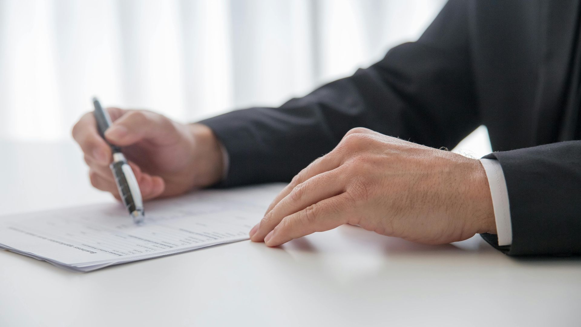 Businessman signing important documents at office desk.