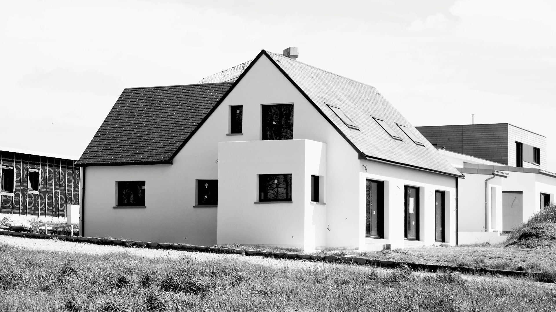 Black and white image of a modern single-family home under construction.