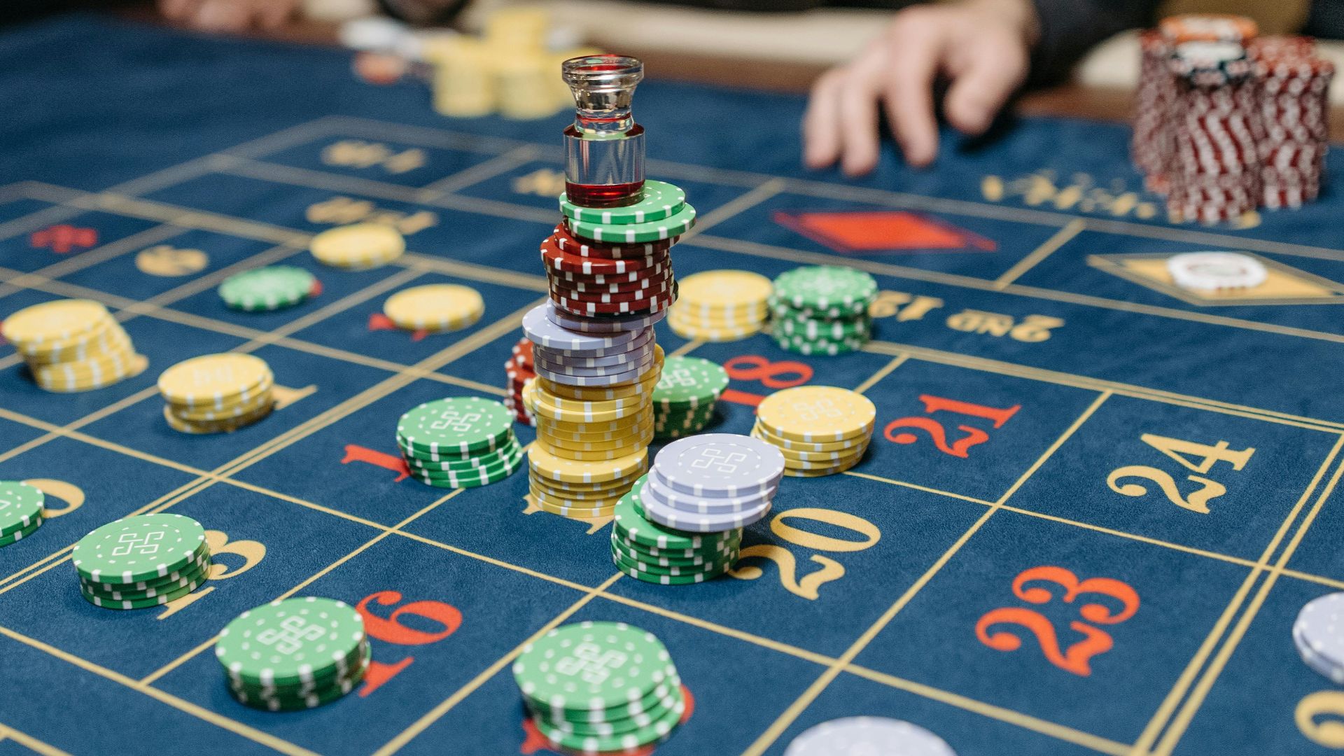 A casino table featuring stacked gaming chips and a roulette layout, suggesting gameplay.