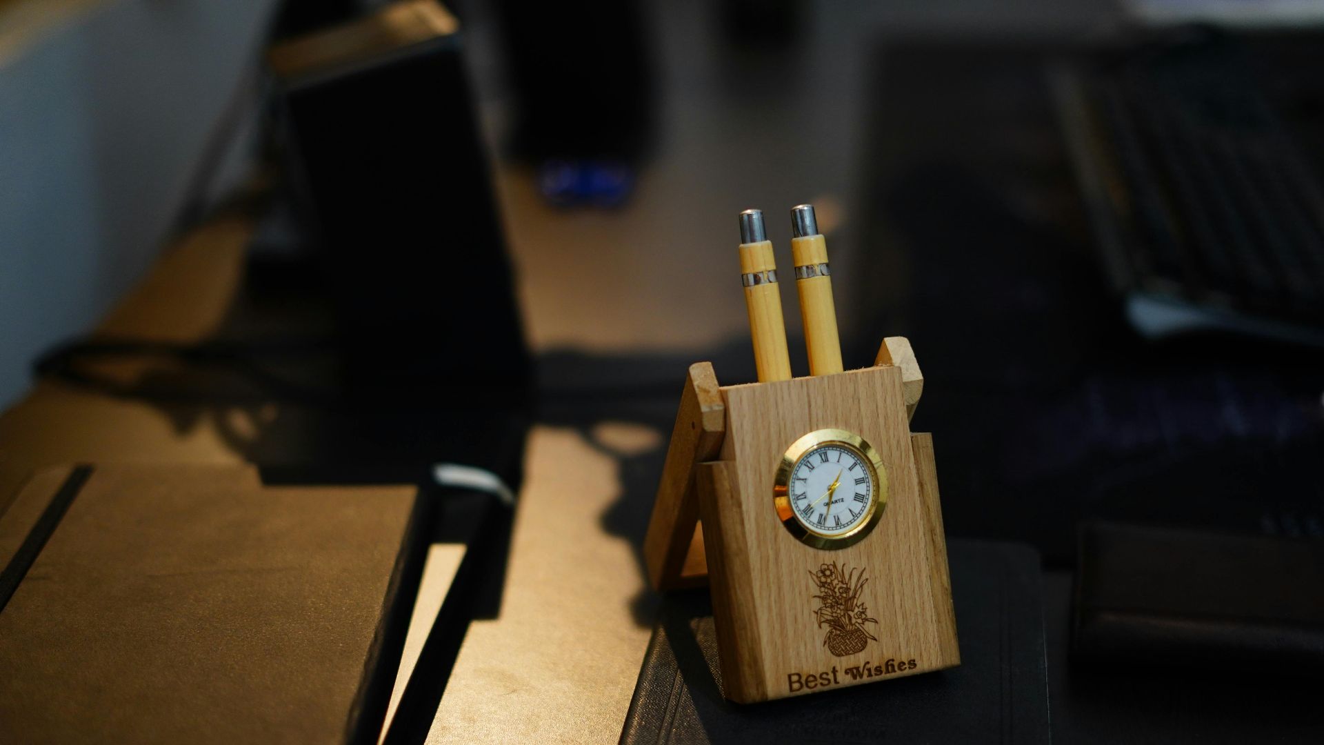 Stylish wooden desk organizer with built-in clock and pens on a modern office desk.
