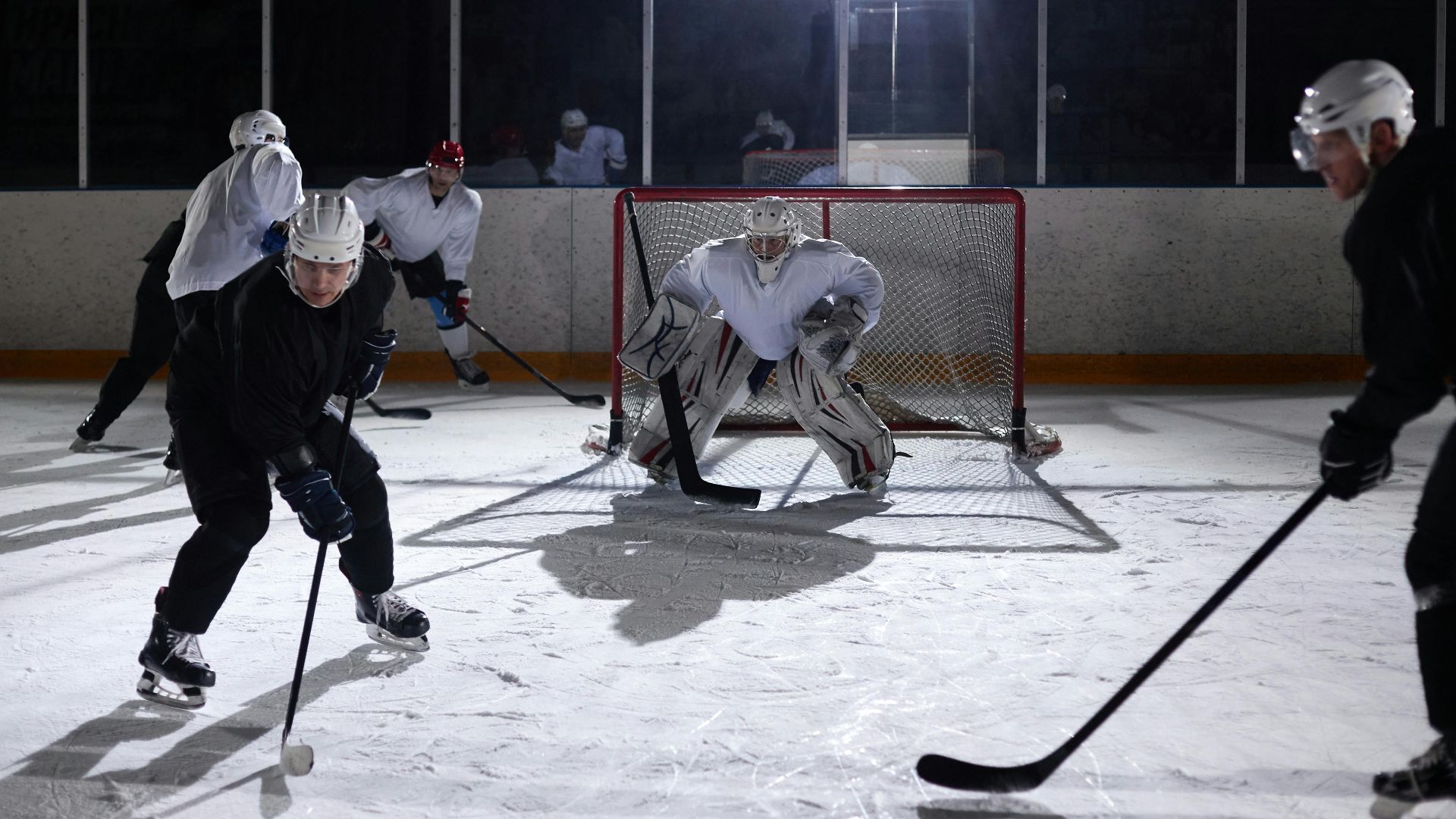 A dynamic moment captured during an ice hockey practice game in an indoor rink.