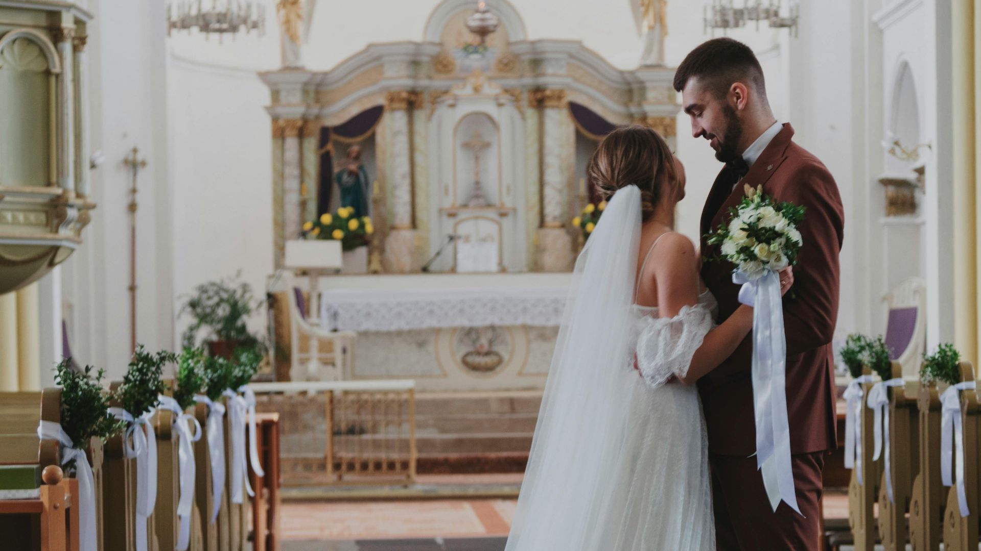A beautiful wedding ceremony in a grand cathedral with bride and groom embracing.