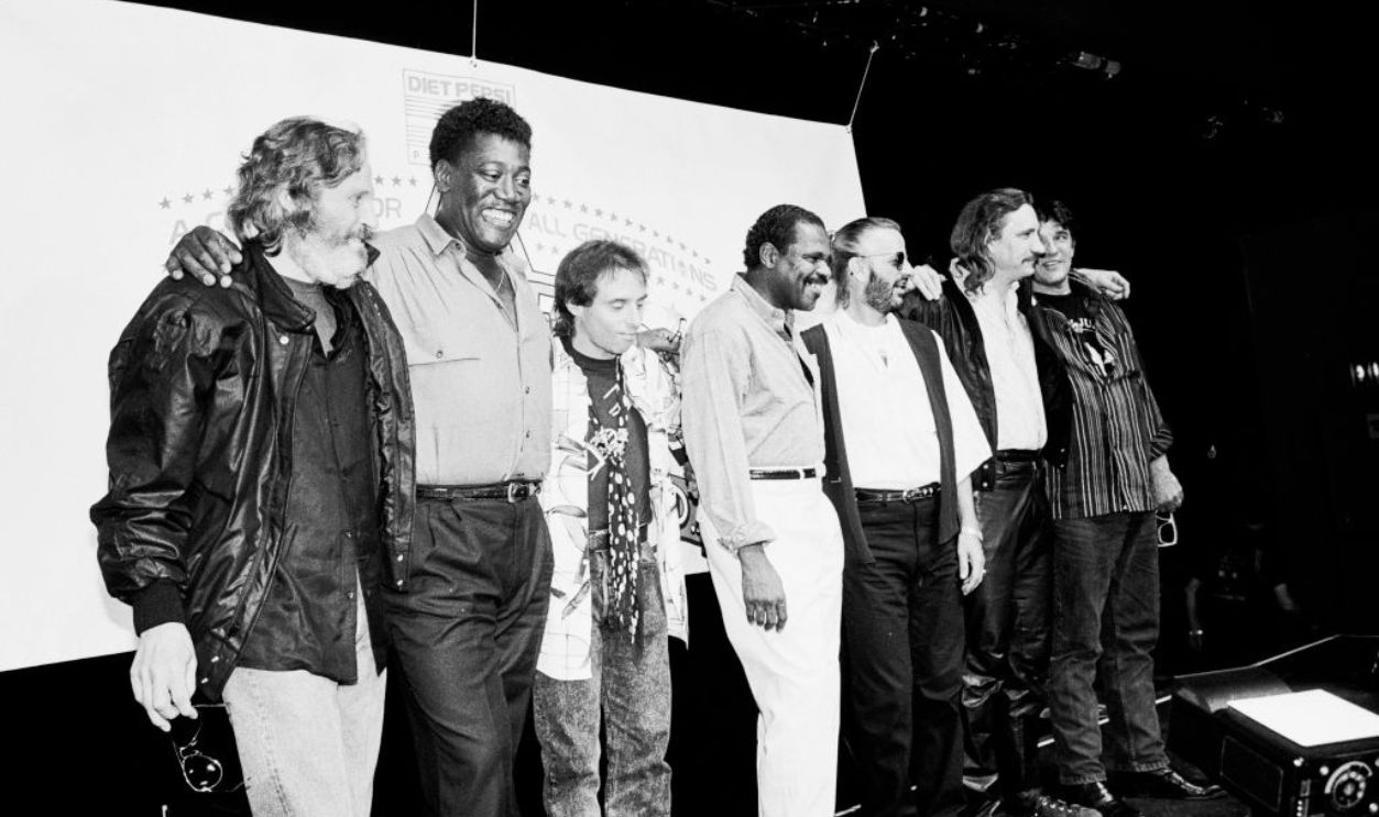 Portrait of, from left, musicians Levon Helm (1940 - 2012), Clarence Clemons (1942 - 2011), Nils Lofgren, Billy Preston (1946 - 2006), Ringo Starr, Joe Walsh, and Rick Danko (1943 - 1999) during a press conference at the Palladium to announce the inaugural tour of Ringo Starr and His All-Starr Band, New York, New York, June 20, 1989. 