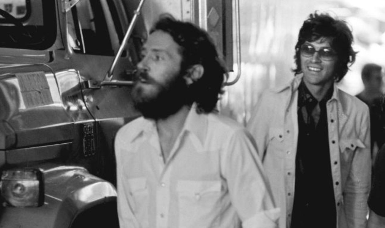 Levon Helm (left) and Robbie Robertson (centre) of The Band, backstage at a Crosby, Stills, Nash and Young concert in Oakland, California, United States, 1974.
