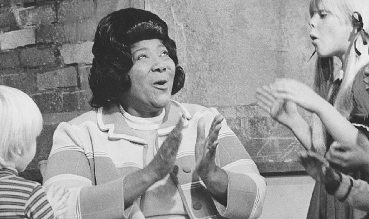 African-American singer and Queen of Gospel Mahalia Jackson and children during filming of the television show Sesame Street, 1975. 