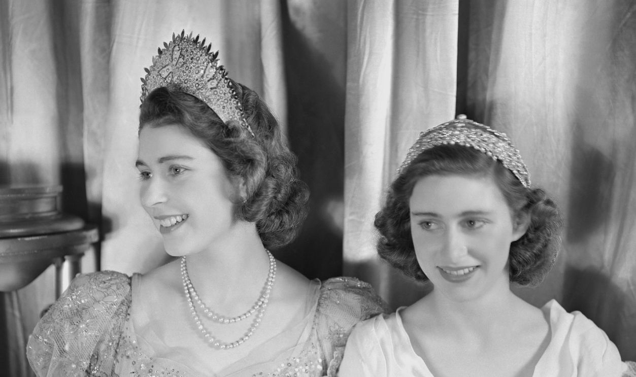 Princess Elizabeth (Queen Elizabeth II) and Princess Margaret (1930-2002), both dressed in elaborate gowns, pictured during a royal pantomime production of 'Old Mother Red Riding Boots' at Windsor Castle, Berkshire, Great Britain, 22 December 1944. 