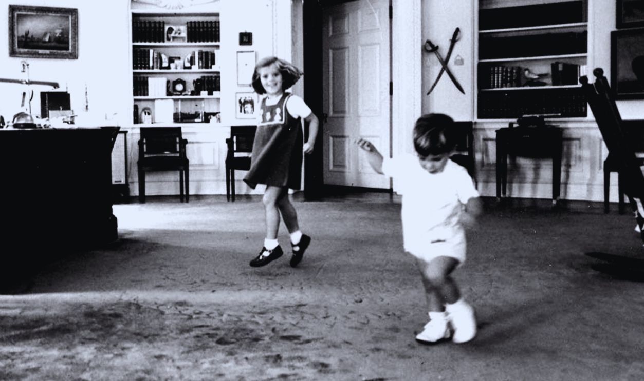Gettyimages - 803231074, Kennedy And Children US President John F Kennedy works in the Oval Office of the White House while children John Kennedy Jr and Caroline Kennedy play, October 10, 1962. 
