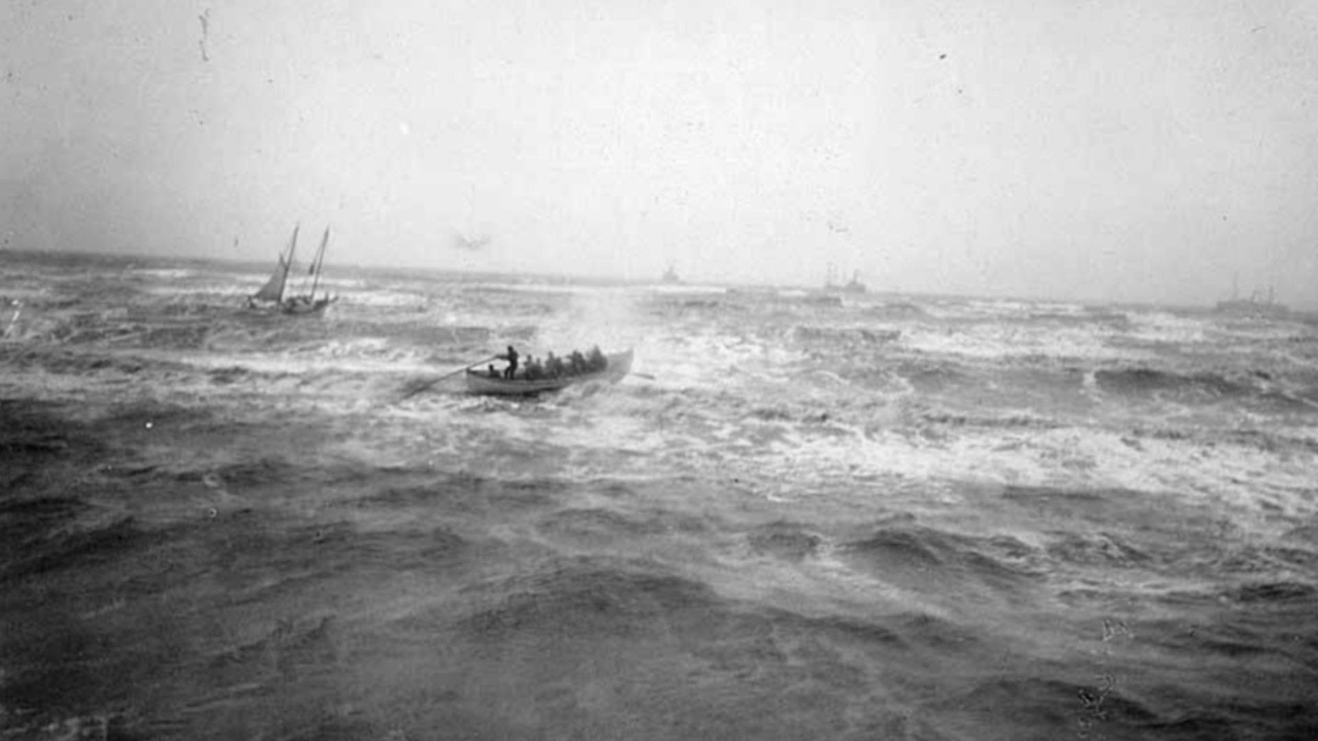 Caption on image: Nome life saving crew making for disabled Sloop Greyhound. Dobbs. 839. 
 PH Coll 788.46 (See also PH Coll 1240.53)
Beverly Bennett Dobbs was born in 1868 near Marshall, Missouri. In 1888 Dobbs moved to Bellingham, Washington and operated a photography studio there for 12 years. In 1900 Dobbs moved to Nome, Alaska and continued to work as a photographer capturing images of Nome, the Seward Peninsula, and Inuit people. In 1909, Dobbs started the Dobbs Alaska Moving Picture Co. and began making films about the Gold Rush. By 1914, Dobbs had moved back to Seattle and was creating more films through the Dobbs Totem Film Company which he ran until his death in 1937.
Subjects (LCTGM): Rescues--Alaska; Sailing ships--Alaska; Rowboats--Alaska
Subjects (LCSH): Greyhound (Sloop)