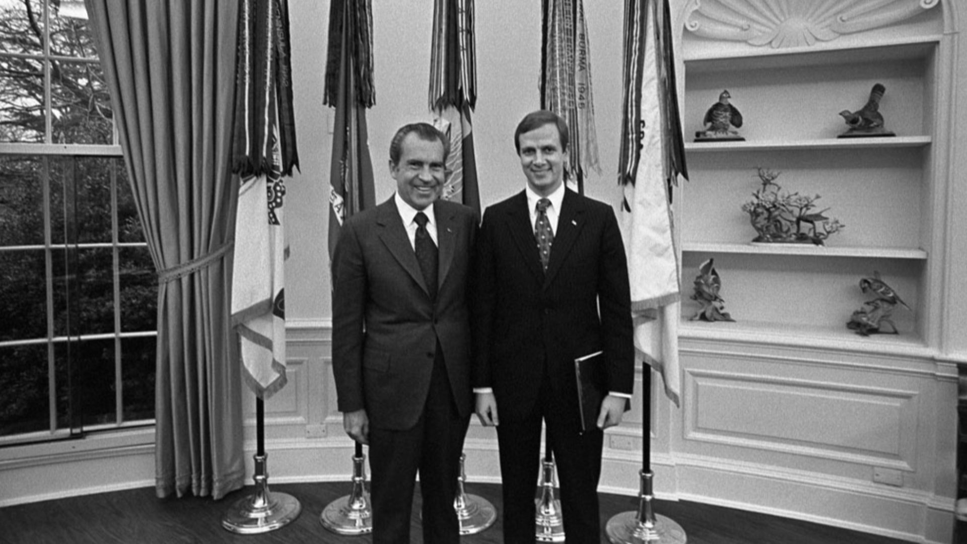 President Nixon poses for a photo opportunity with Staff Assistant Gordon C. Strachan in the Oval Office