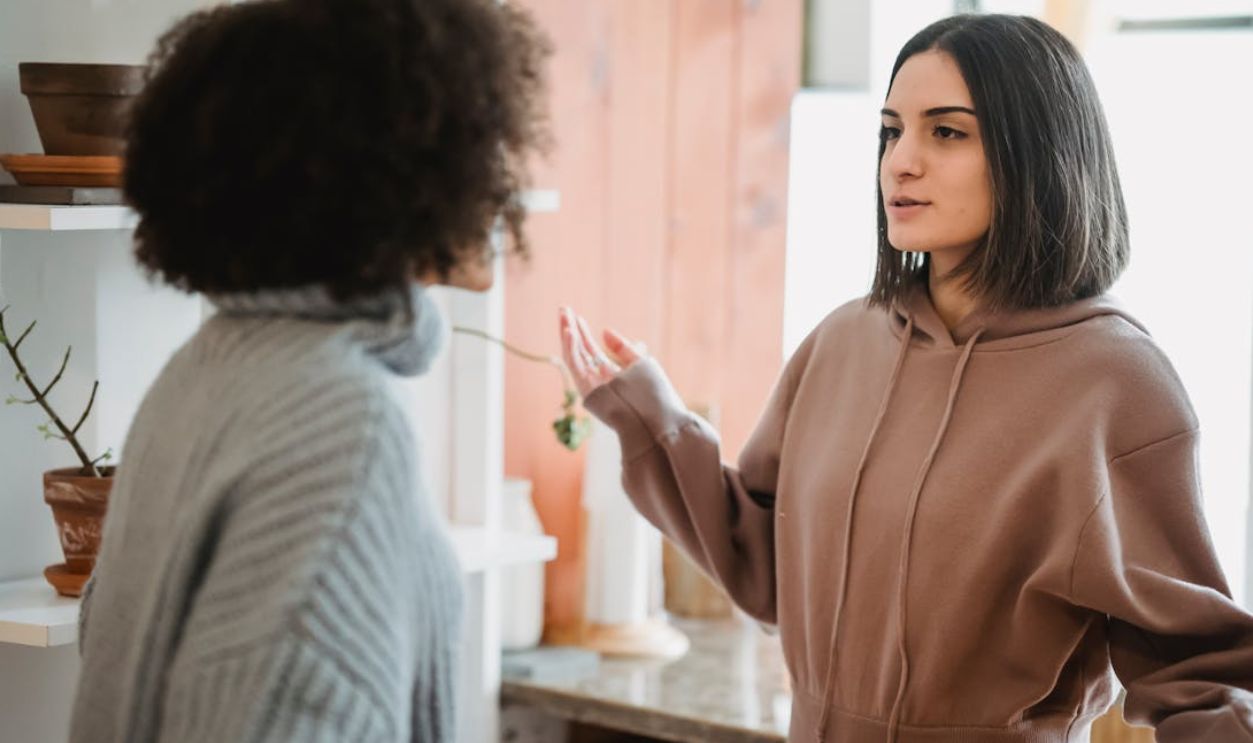 Two women engage in a serious conversation in a cozy indoor setting