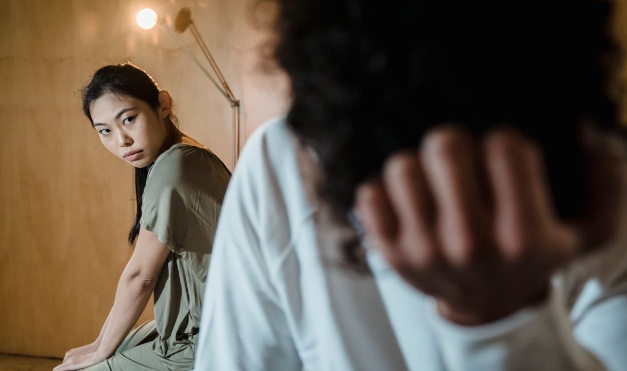 A couple experiencing tension and emotional crisis in a dimly lit room