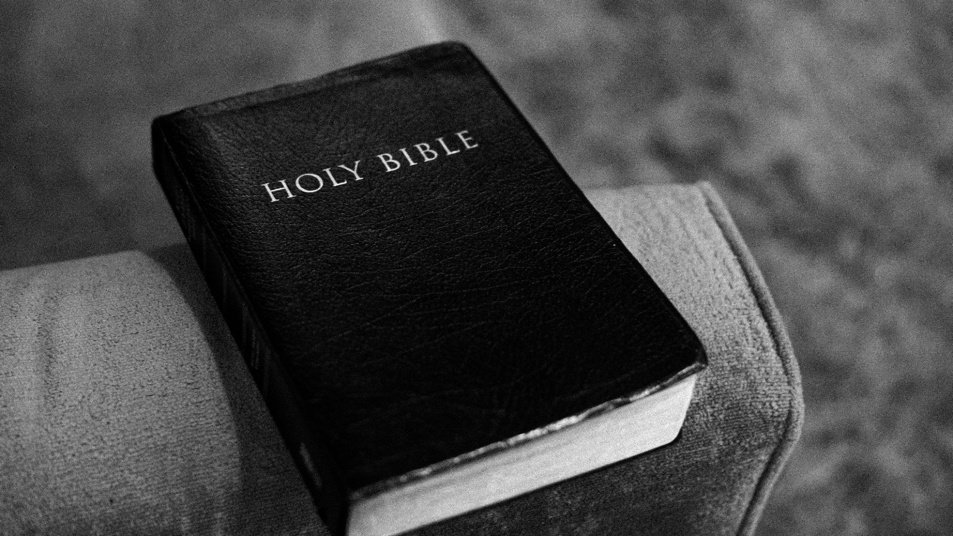 a black and white photo of a bible on a couch