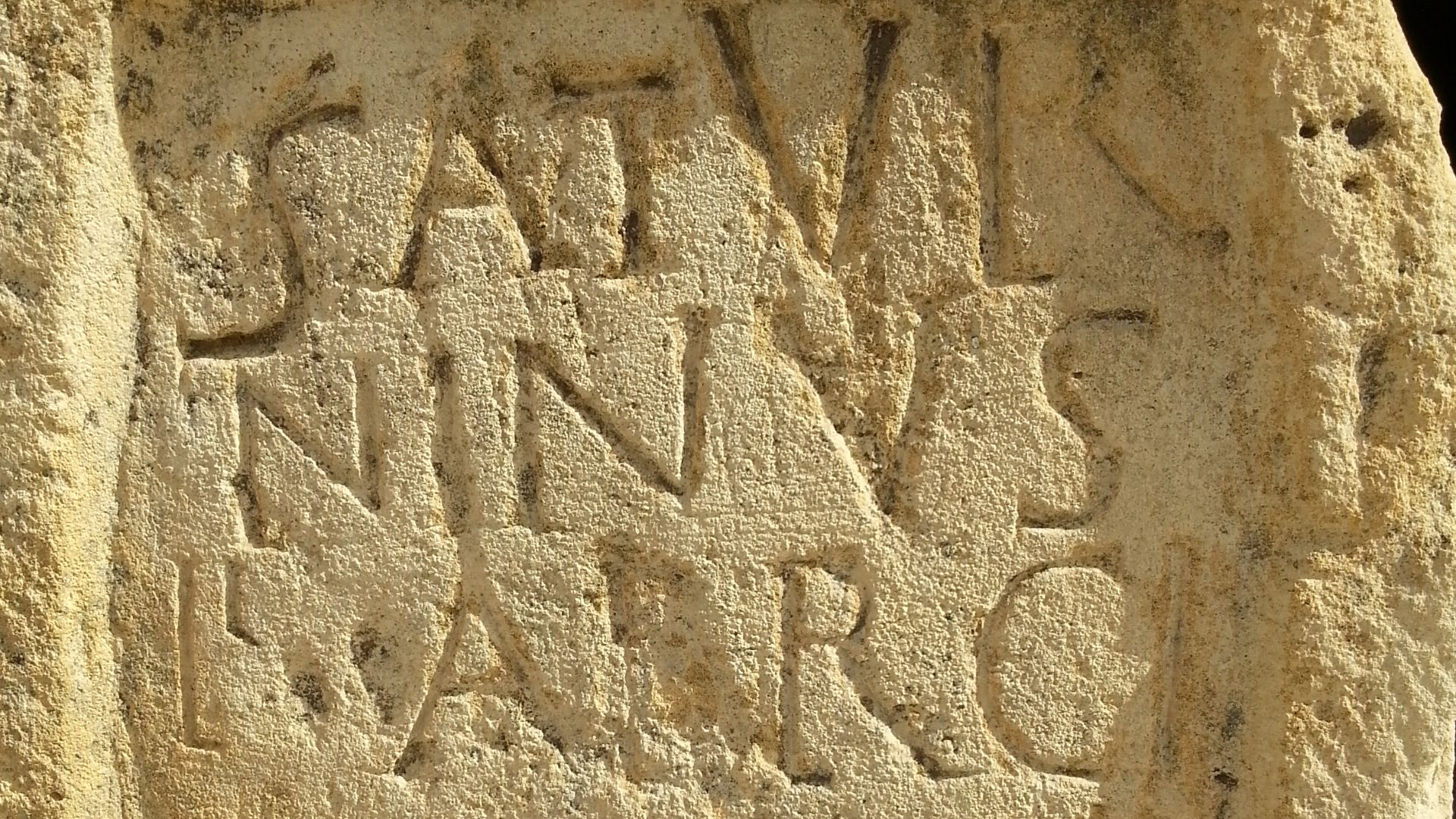 Dedicatoria del centurión Niger, de la cohorte Hispanurum, a Saturninus, hijo de Fabricus, centurión de la primera cohorte de los españoles.
Reempleada en construcciones tardías en el oeste del túmulo. Calcárea. Encontrada en 1956 en Volublis