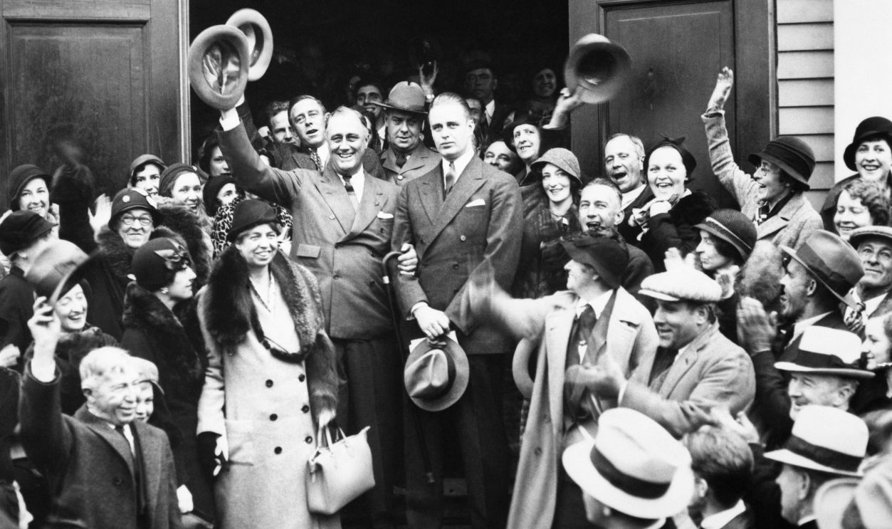 President-elect, and Governor of New York, Franklin D. Roosevelt stands arm in arm with his son James. Roosevelt's wife Eleanor is to his right on a lower step. Roosevelt waves his hat while supporters cheer his victory in the presidential election on 1932.