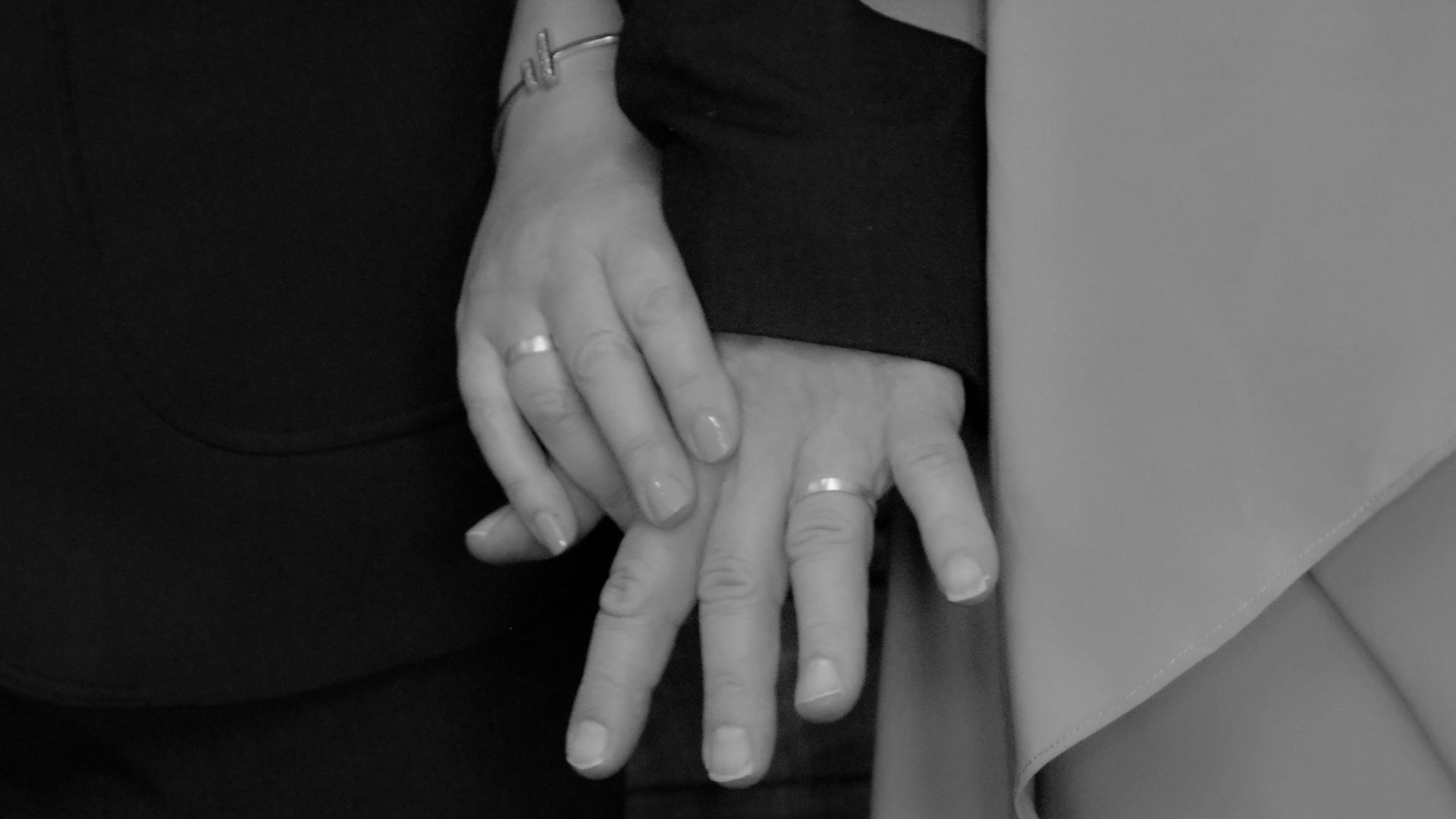 Couple holding hands wearing wedding rings
