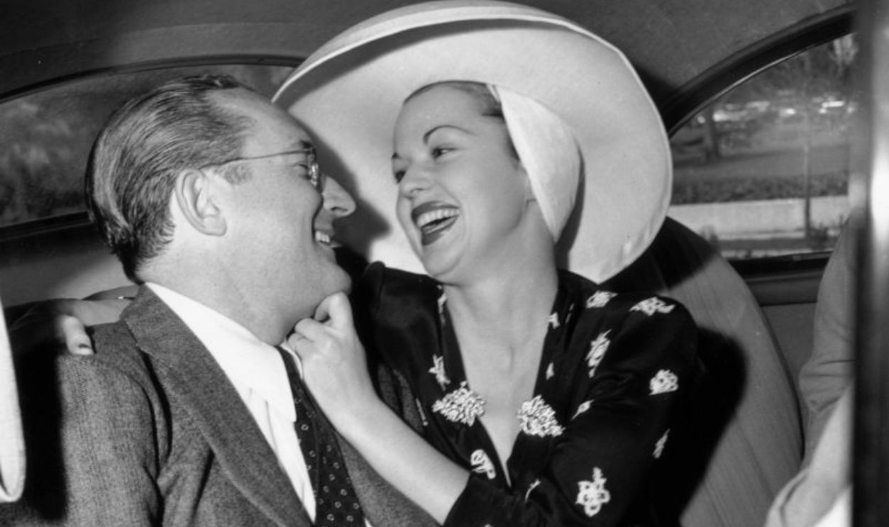 circa 1945: EXCLUSIVE American jazz bandleader Tommy Dorsey (1905 - 1956) (L) and his wife, Pat, smile at each other while sitting in the back seat of an automobile. She wears a wide-brimmed sun hat.