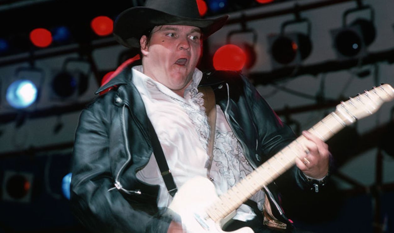 (Original Caption) : 1978-Rock and roll musician Meatloaf is shown on stage playing guitar in concert.