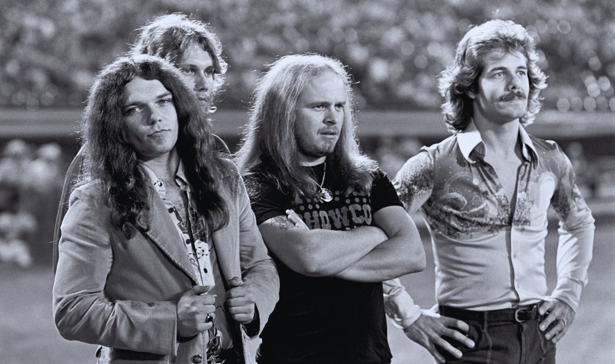 Gettyimages - 74736504, Lynyrd Skynyrd Members Featured At Braves Game, Atlanta ATLANTA - APRIL 15: (L-R) Gary Rossington, Steve Gaines and Ronnie Van Zant of Lynyrd Skynyrd and country singer-songwriter Freddy Weller are announced on the field before the Season Opening Atlanta Braves Game at Atlanta-Fulton County Stadium on April 15, 1977 in Atlanta, Georgia, United States.
