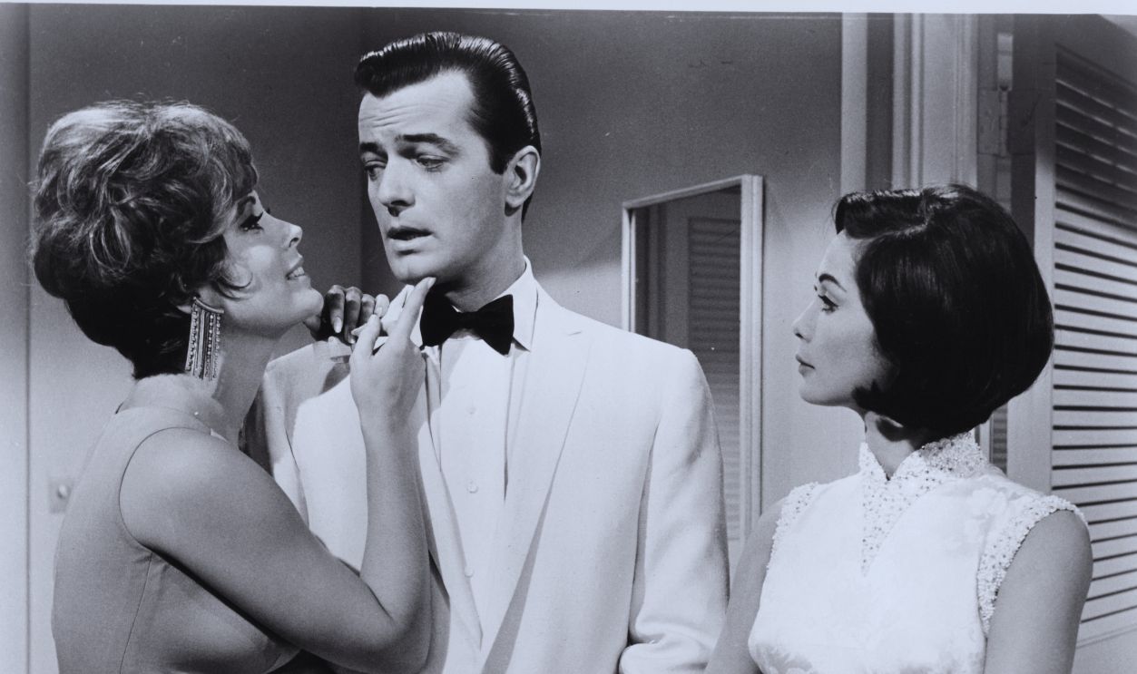 Gettyimages - 129734082, Robert Goulet In 'Honeymoon Hotel' Robert Goulet hardly knows where to look when Jill St John makes him the center of her attentions and Nancy Kwan matches the proceedings in a scene from the film 'Honeymoon Hotel', 1964.  
