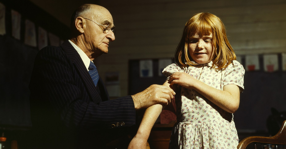 Dr. Schreiber of San Augustine giving a typhoid inoculation at a rural schoo