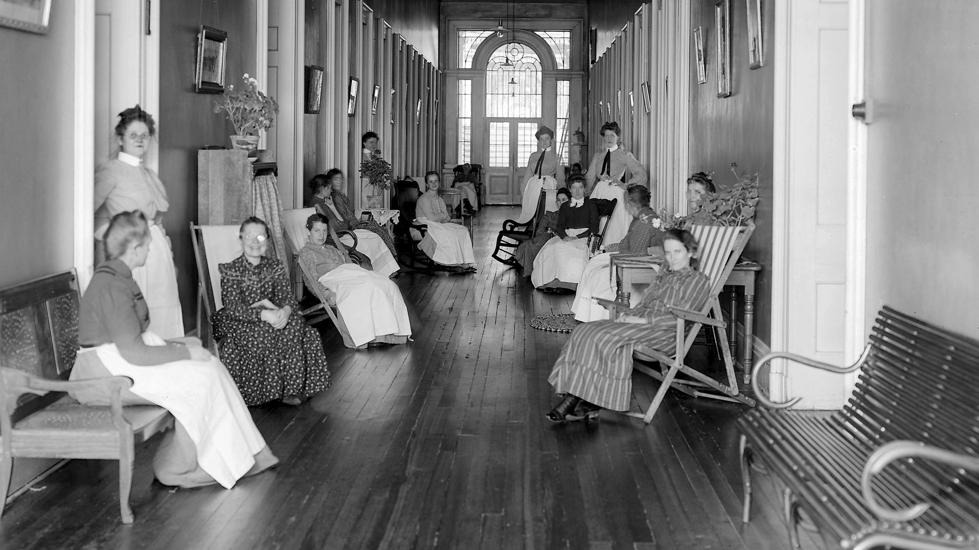 Patients and staff of the St. Louis City Insane Asylum sit in chairs or stand in doorways along a clean and neat hallway posing for the camera.
Originally called the St. Louis County Lunatic Asylum, the separation of the county and the City of St. Louis p