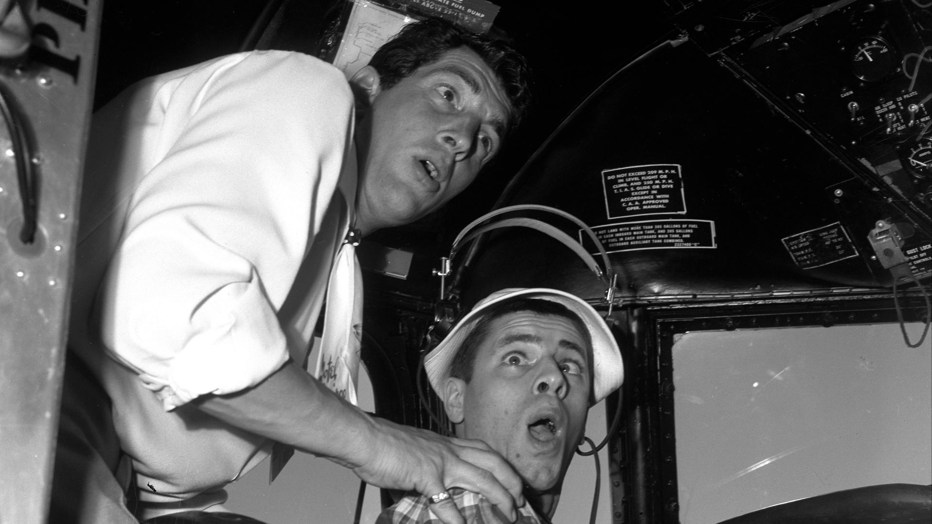 Comedians Dean Martin and Jerry Lewis mugging it up in cockpit of airplane