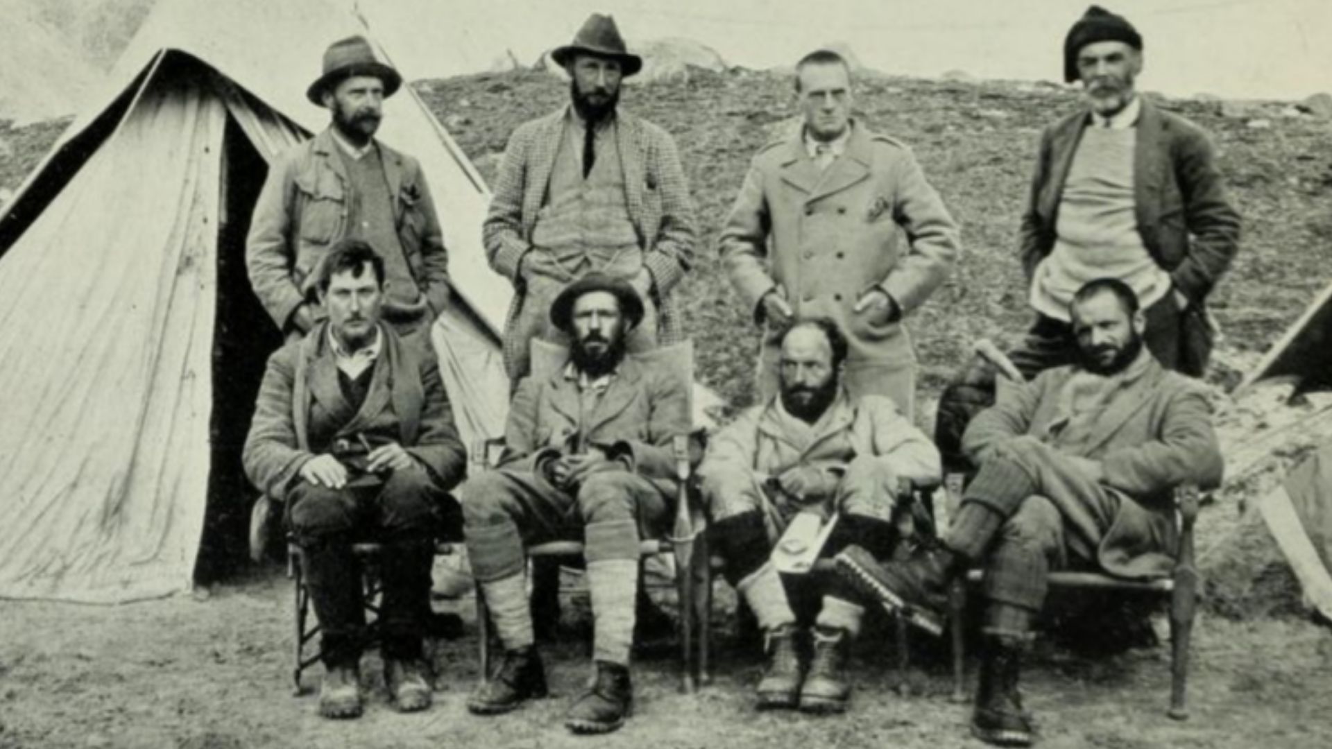 1921 Mount Everest reconnaissance expedition team members. Taken at 17,300 advanced base camp.
Standing (l-r): Wollaston. Howard-Bury. Heron. Raeburn. Sitting (l-r): Mallory. Wheeler. Bullock. Morshead.
Published in Howard-Bury, C. K. (1922). Mount Ever