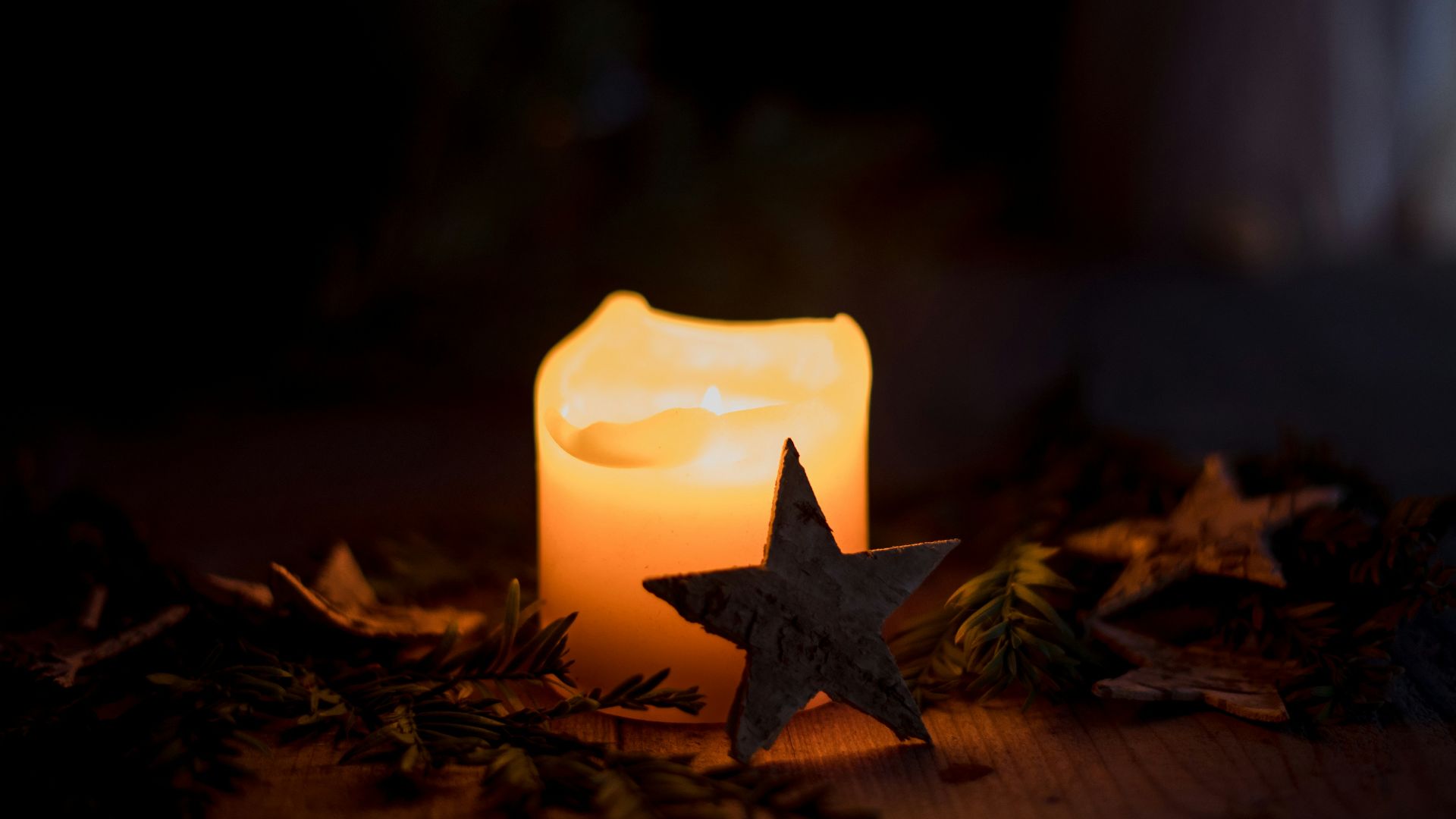 a lit candle with a star on top of it