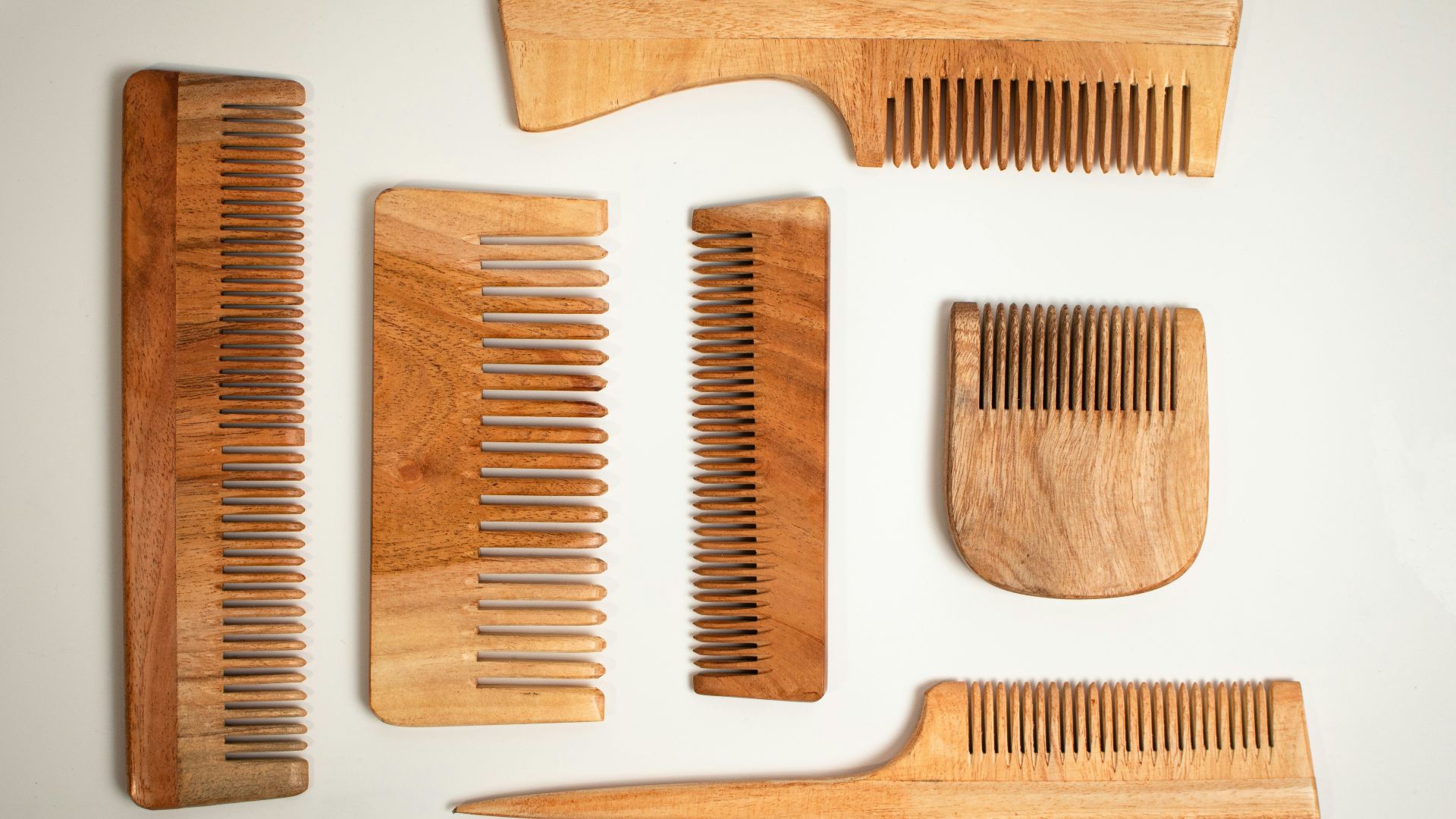 a collection of wooden combs and combs on a white surface