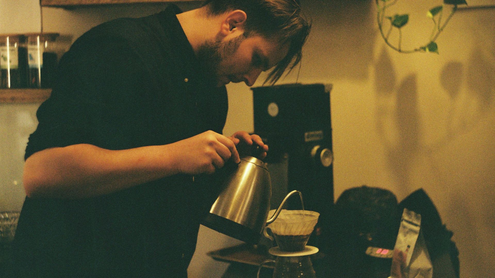 man in black shirt holding black and silver coffee maker