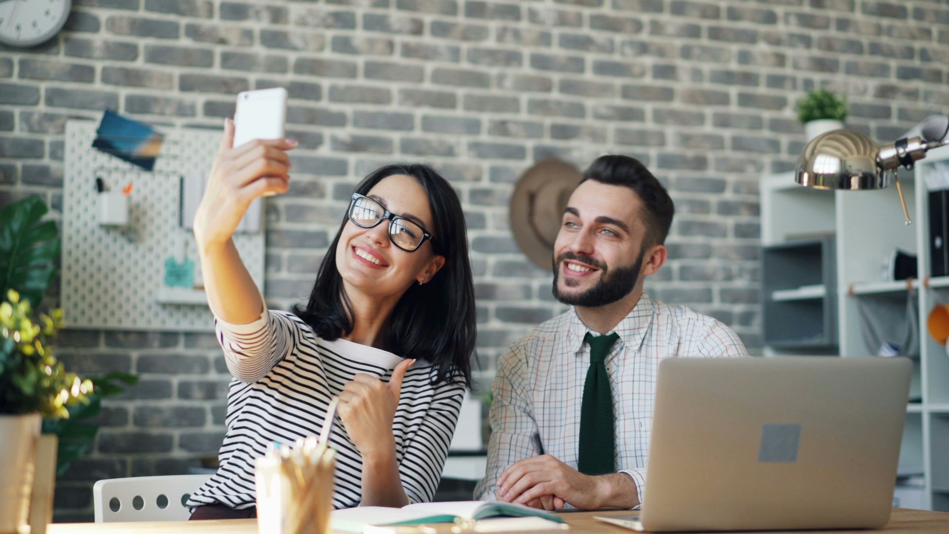 a man and a woman sitting at a table with a laptop