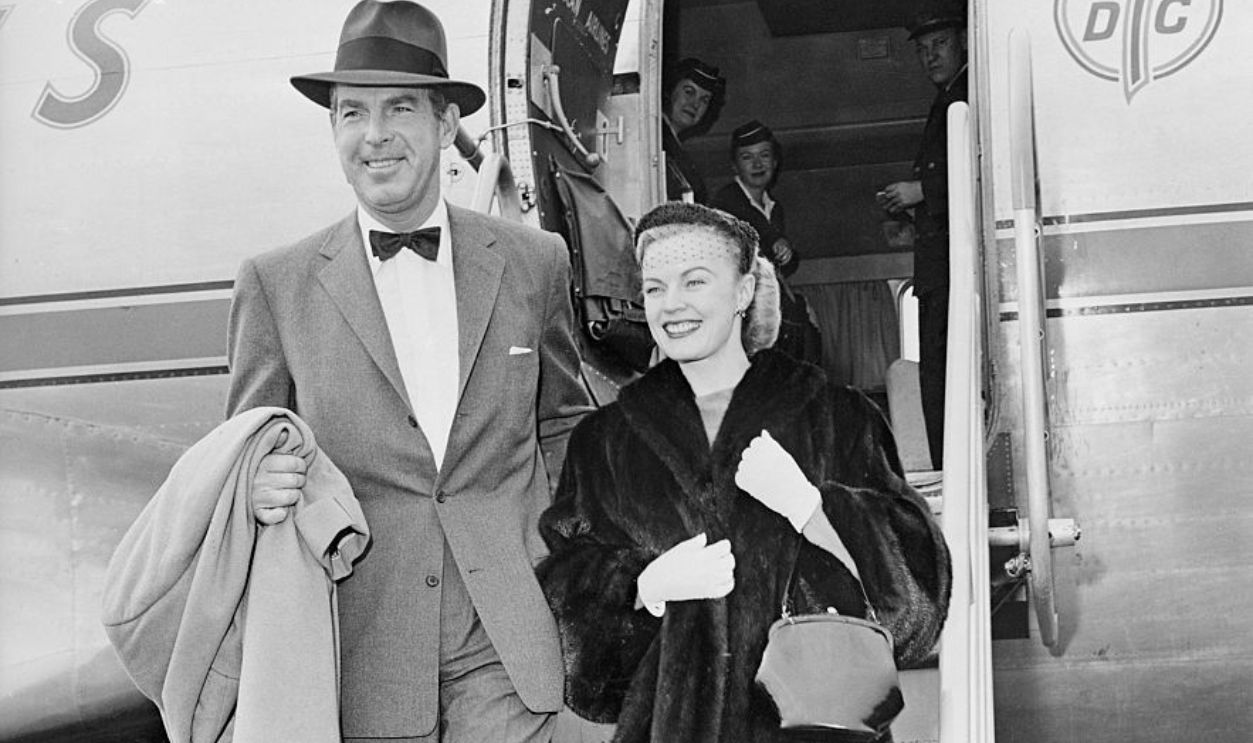 (Original Caption) Happy smiles light the faces of actor Fred MacMurray and his wife, actress June Haver, as they step from a plane at Los Angeles. Returning from a coast-to-coast tour in connection with the movie At Gunpoint. The MacMurrays were obviously glad to be back home.