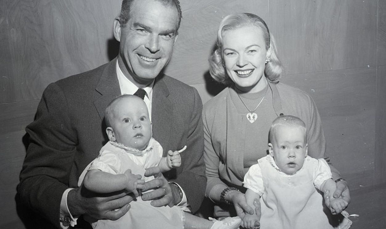 (Original Caption) 12/7/56-Hollywood, California: Actor Fred MacMurray and his actress-wife, June Haver, received a real Christmas present here Dec. 4th when the court approved their adoption of seven-month-old twin girls. Fred is shown holding Laurie Anne and June holds Katherine Marie. The MacMurrays have two other children adopted by the actor during an earlier marriage.