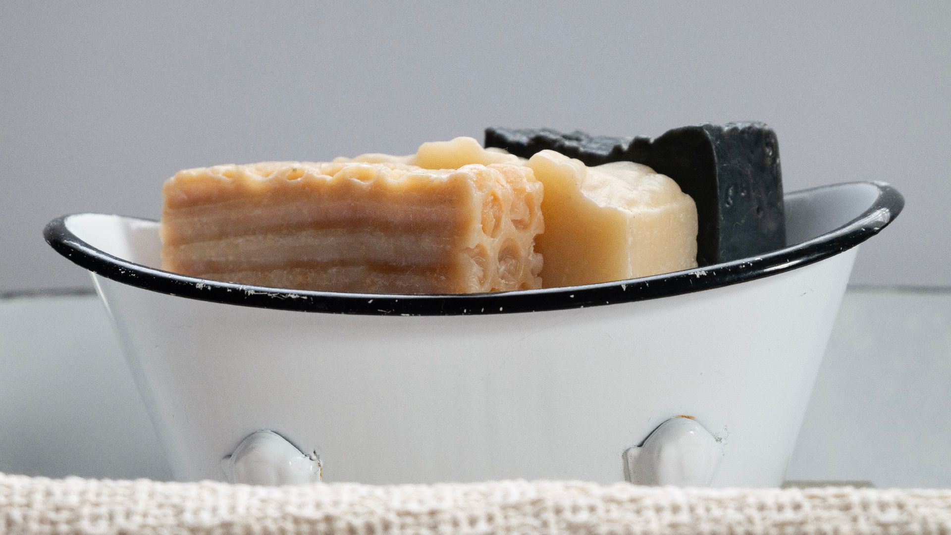Close-up of assorted handmade soaps in a vintage soap dish.
