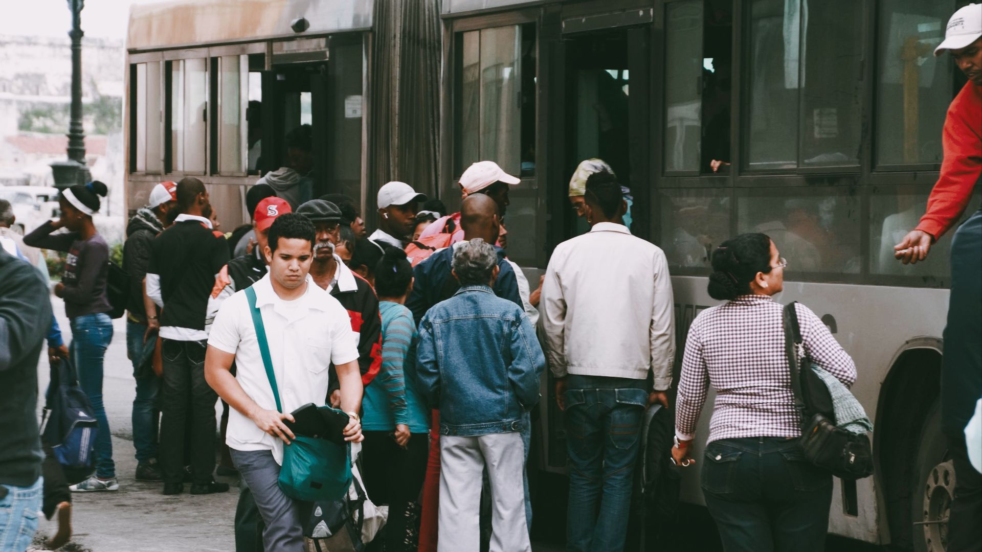 A bustling city scene of diverse people boarding a public transport bus.