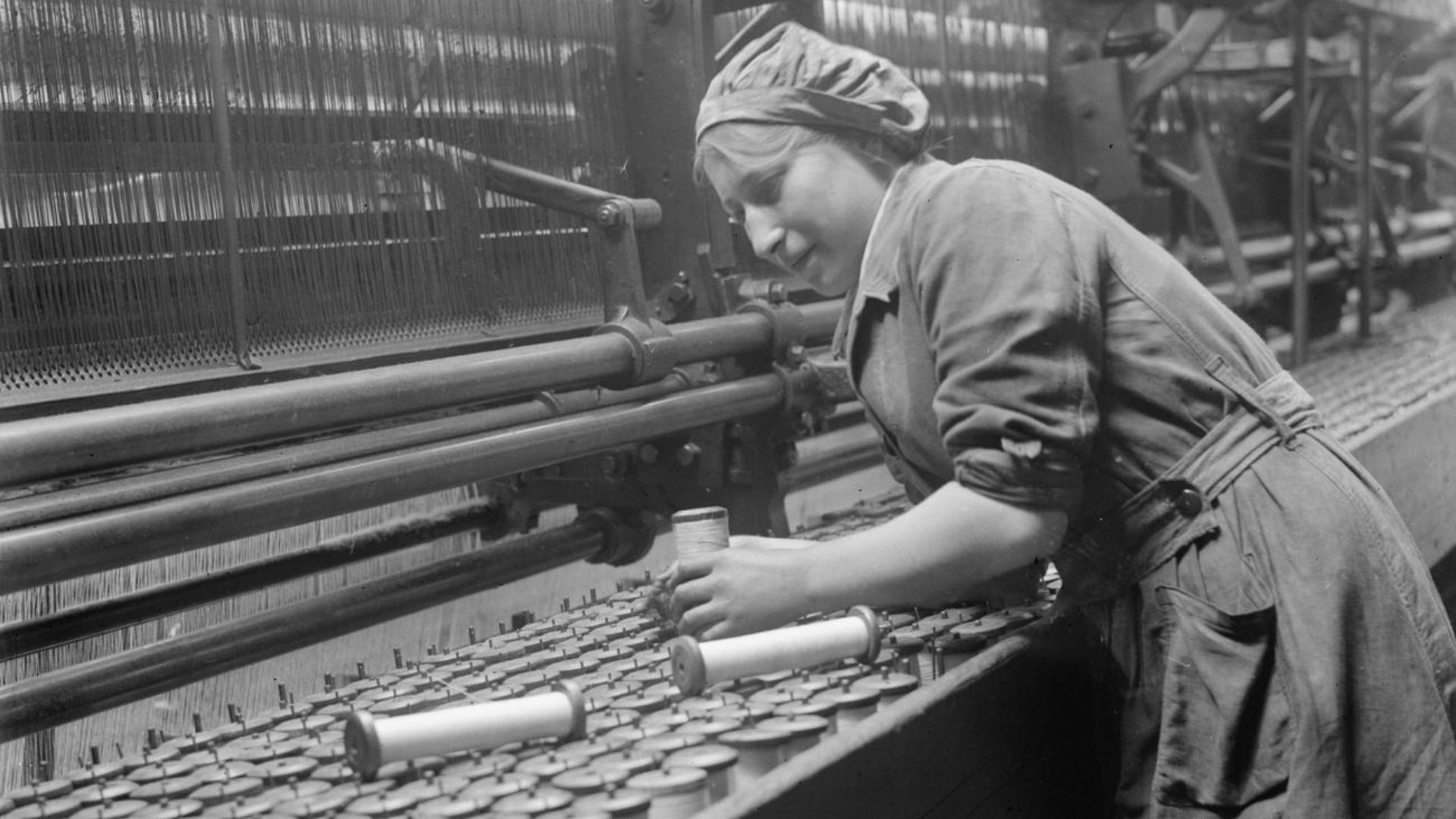 Industry during the First World War- Leicestershire
A female worker replaces empty spools of thread in a lace curtain machine in a Nottingham factory in September 1918.