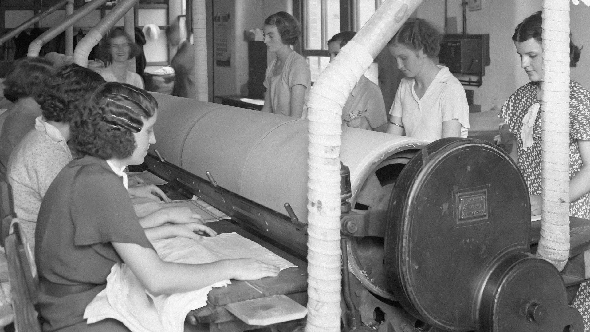 a group of women working on a machine in a factory
