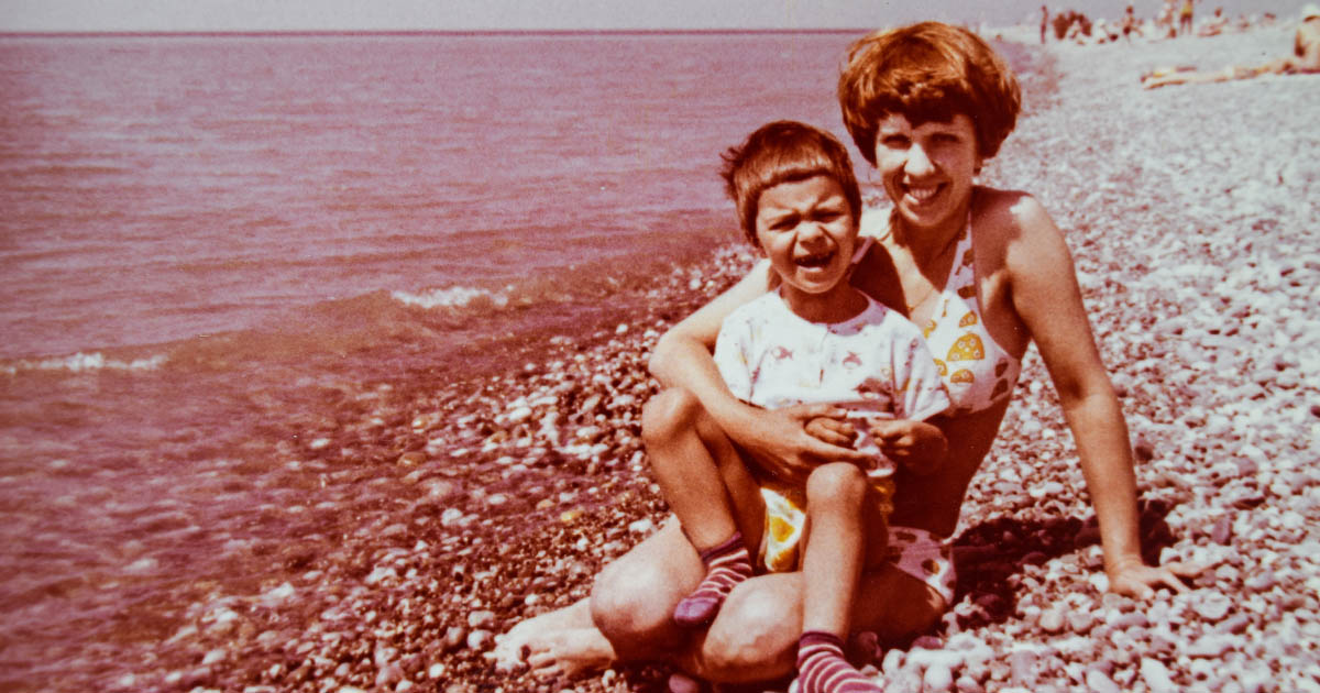 Vintage photo of a mother and child on a beach in 1970