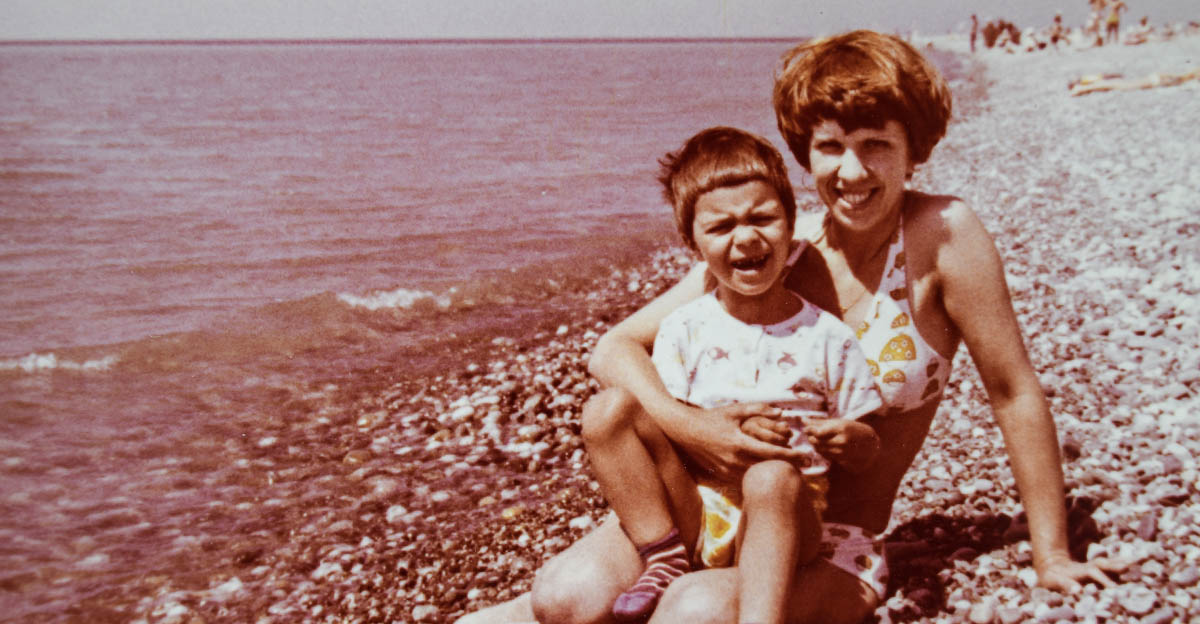 Vintage photo of a mother and child on a beach in 1970