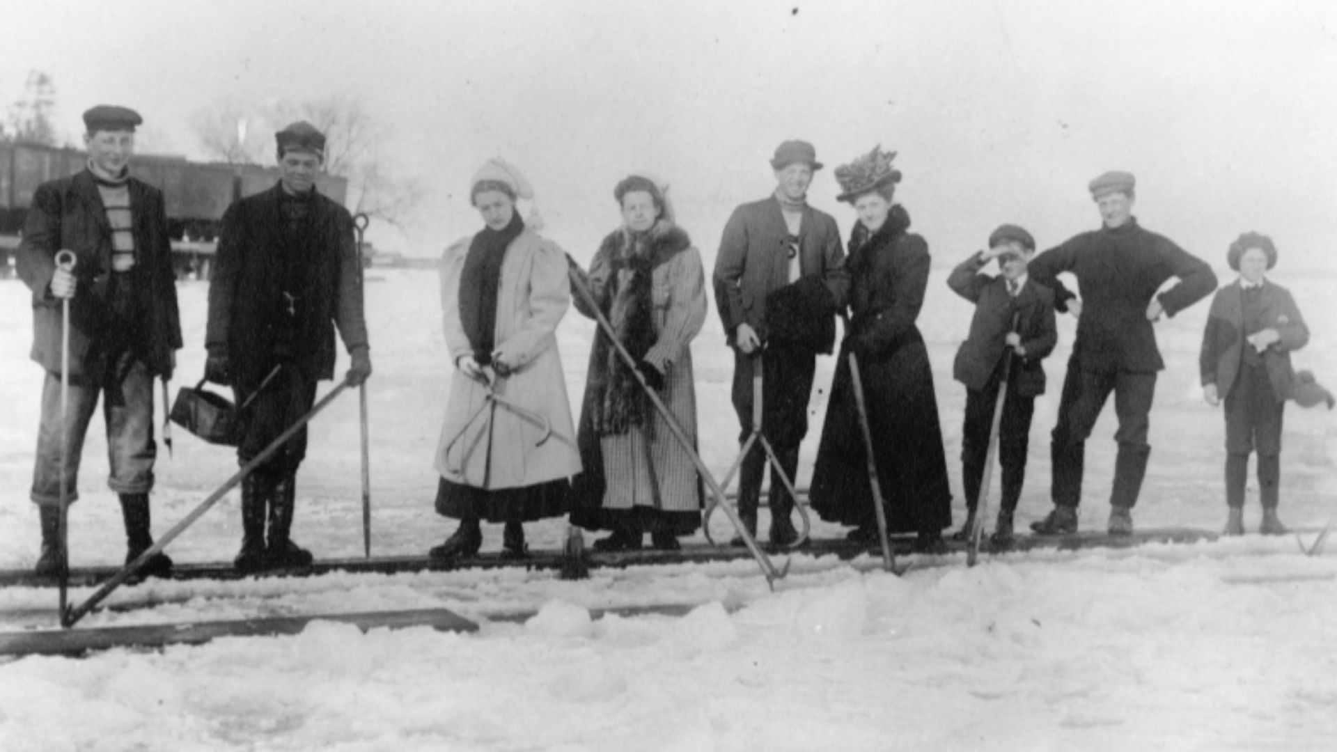 Workers, their wives and children pose at ice cutting operations on Lake Simcoe near Jackson's Point, Ontario in 1895. A Grand Trunk Railway train waits in the background.
