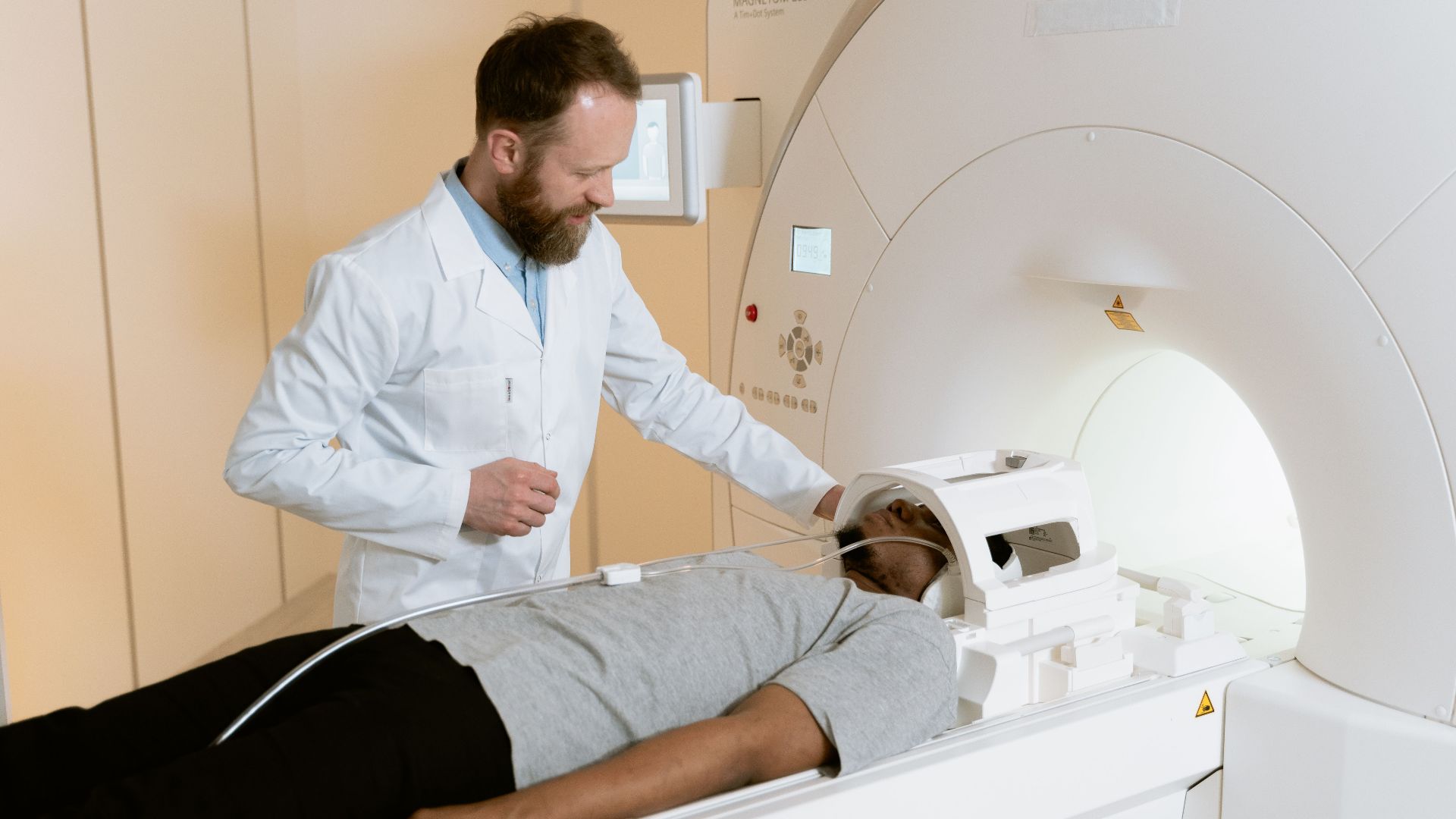 Doctor assists patient undergoing MRI scan in healthcare facility.